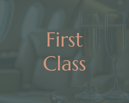 Two glasses of champagne on a tray with the words "First Class" overlayed