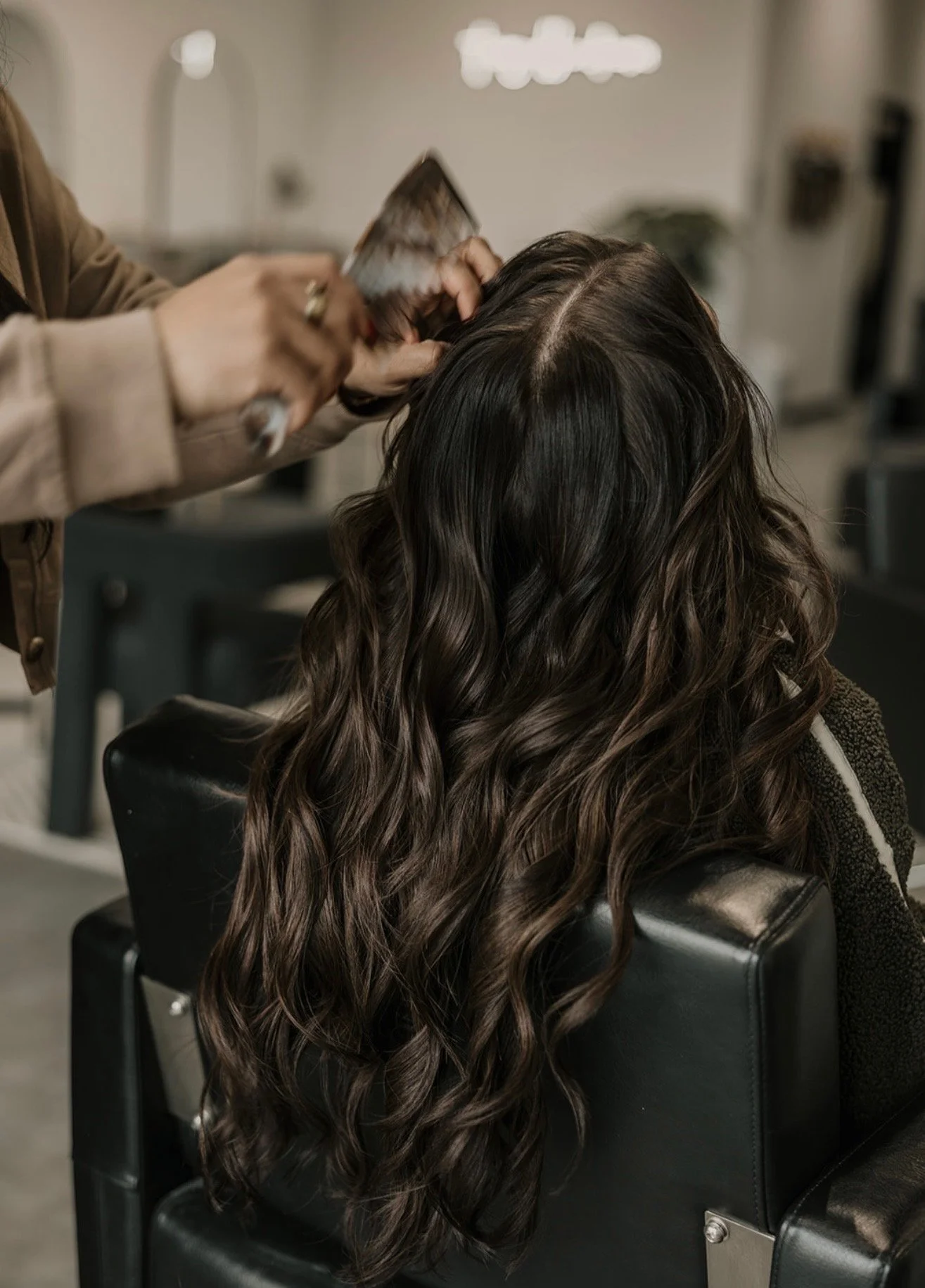 Close-up of seamless, healthy Invisible Bead Extensions (IBE) providing length and fullness for a client at The Industry.