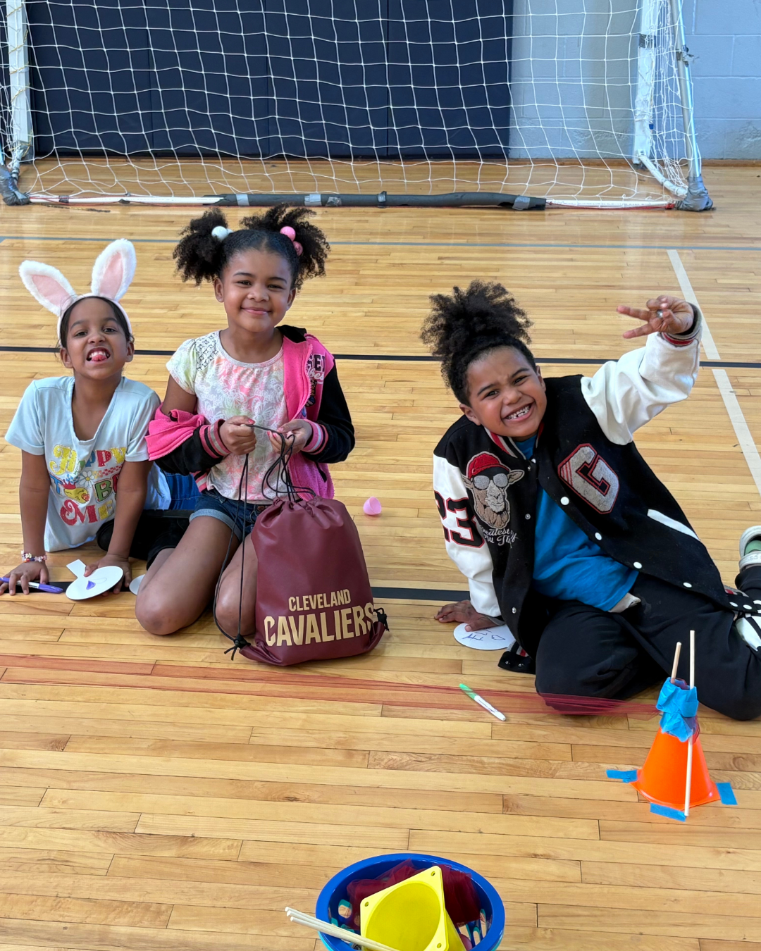three girls sitting on gym floor