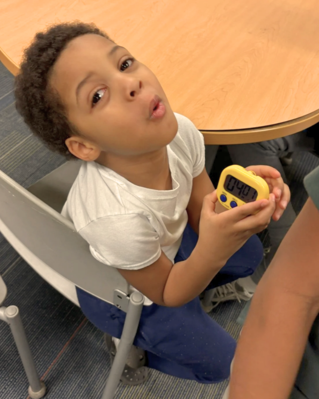 boy with heartrate monitor sitting in chair looking up at camera