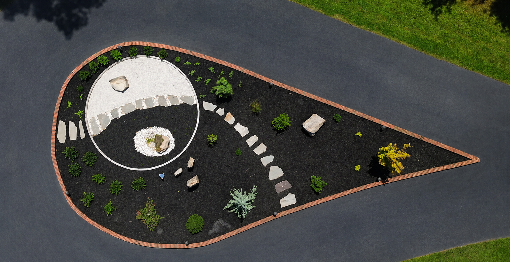 From above, the garden reveals its full composition—an intentional balance of geometry, movement, stone, and planting shaped into a quiet moment within the arrival landscape.