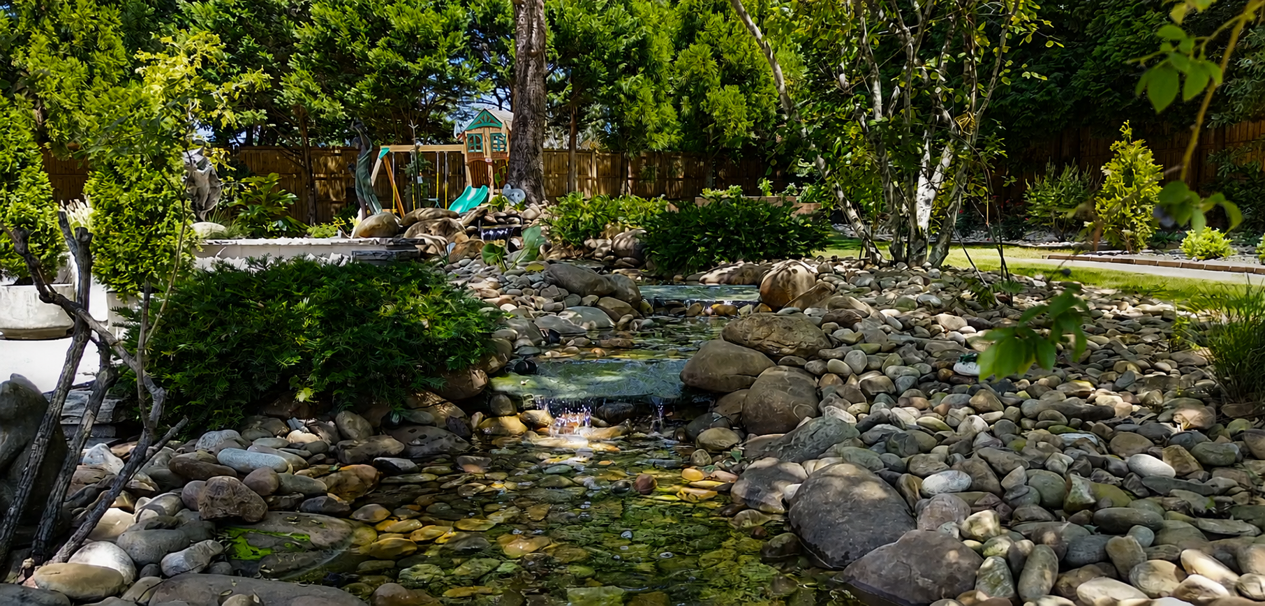 Water becomes the quiet heart of the garden—moving through stone and shade to create sound, reflection, and a deeper sense of immersion.