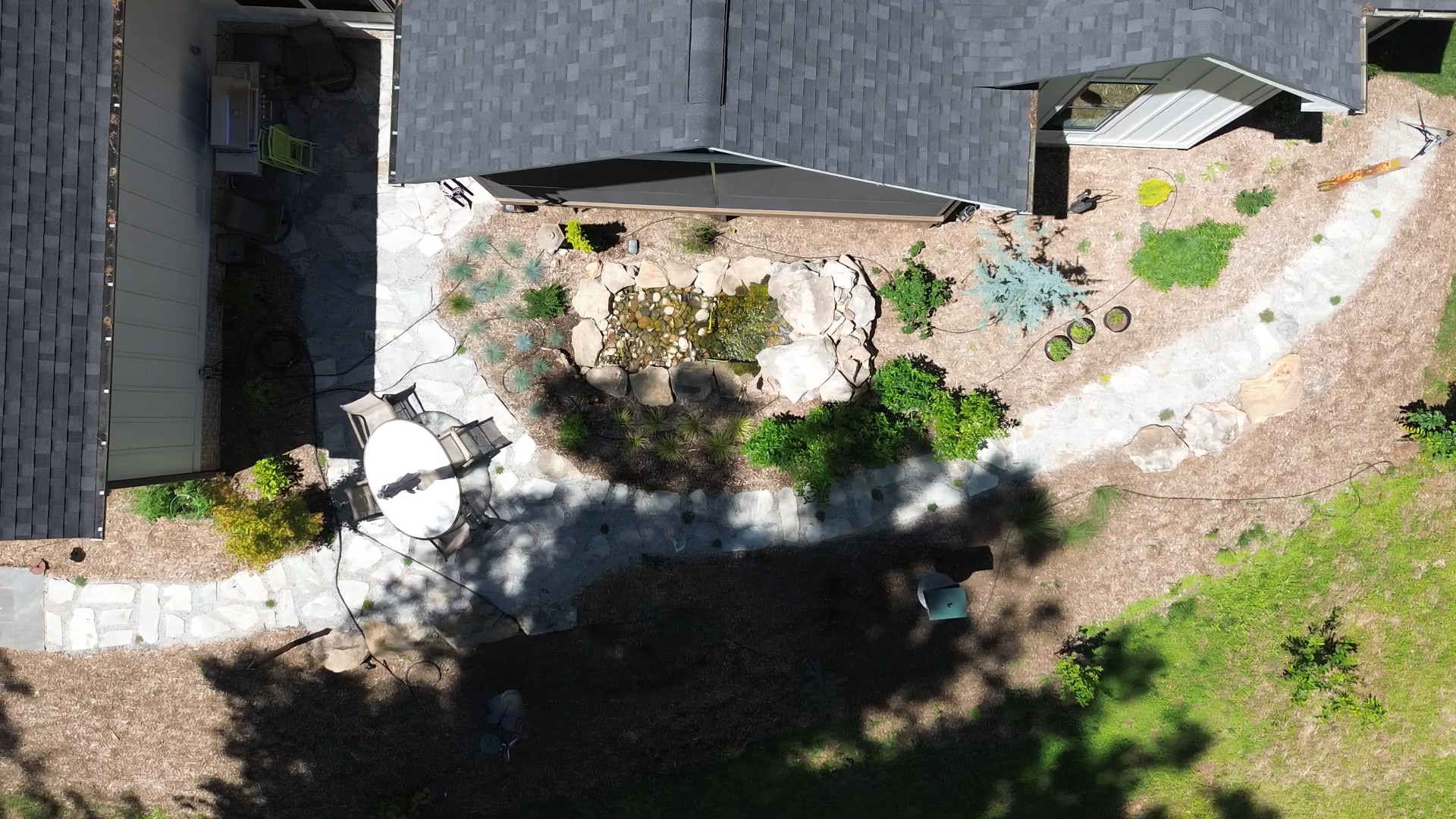 The completed landscape reflects the original design vision, blending natural stone, layered planting, and water into a cohesive woodland retreat that feels both intentional and deeply rooted within its surroundings.