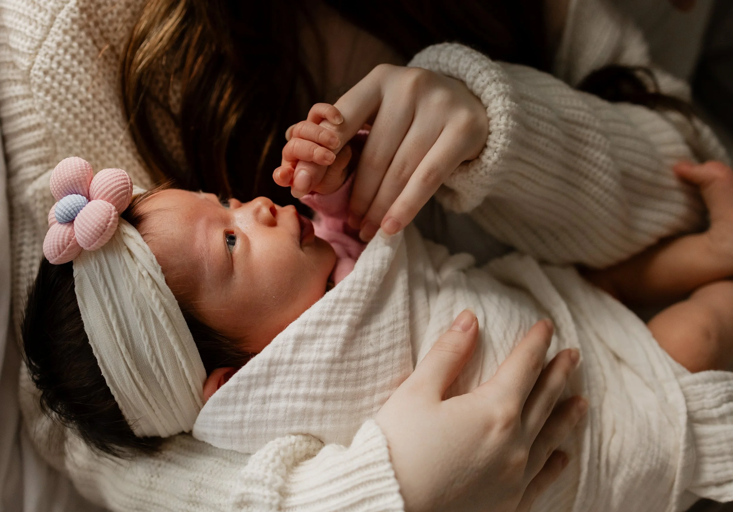 Newborn baby in mother's arms in home