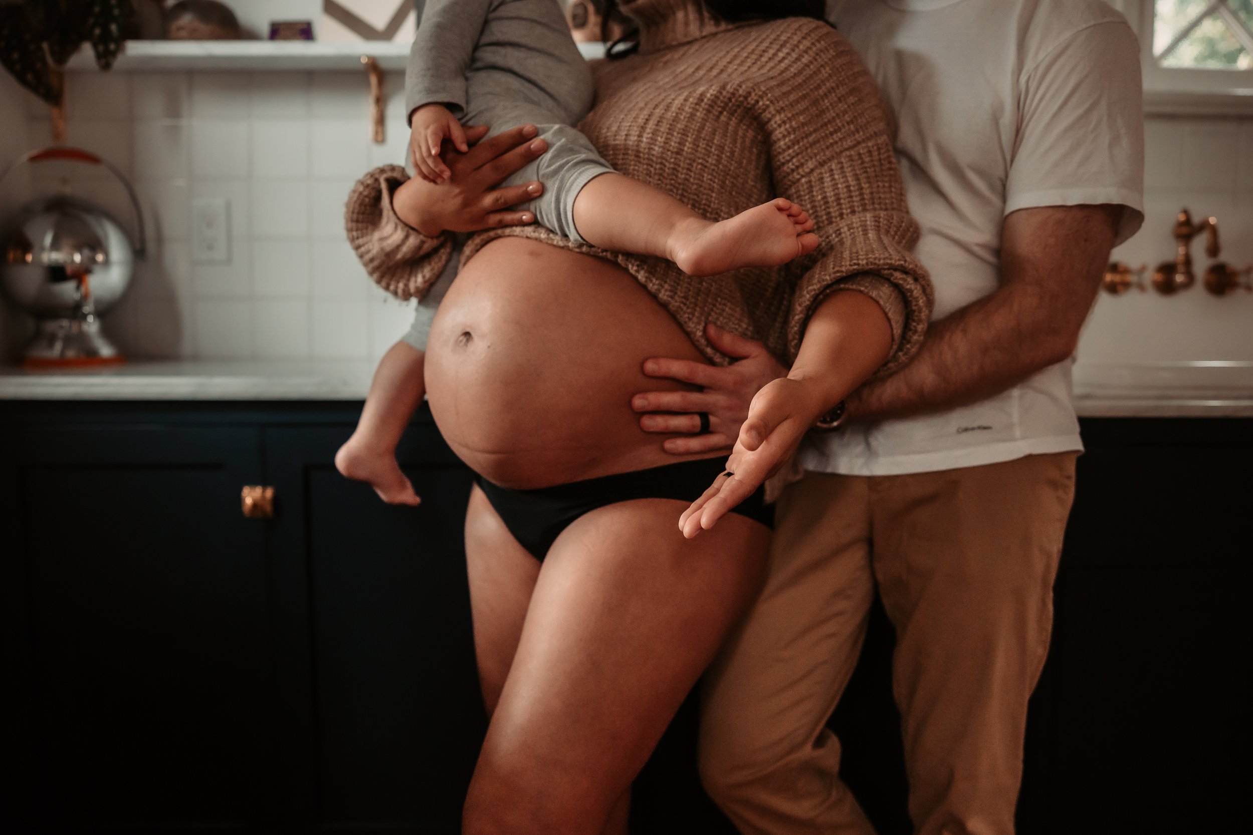 Close of of pregnant belly during family maternity photography session