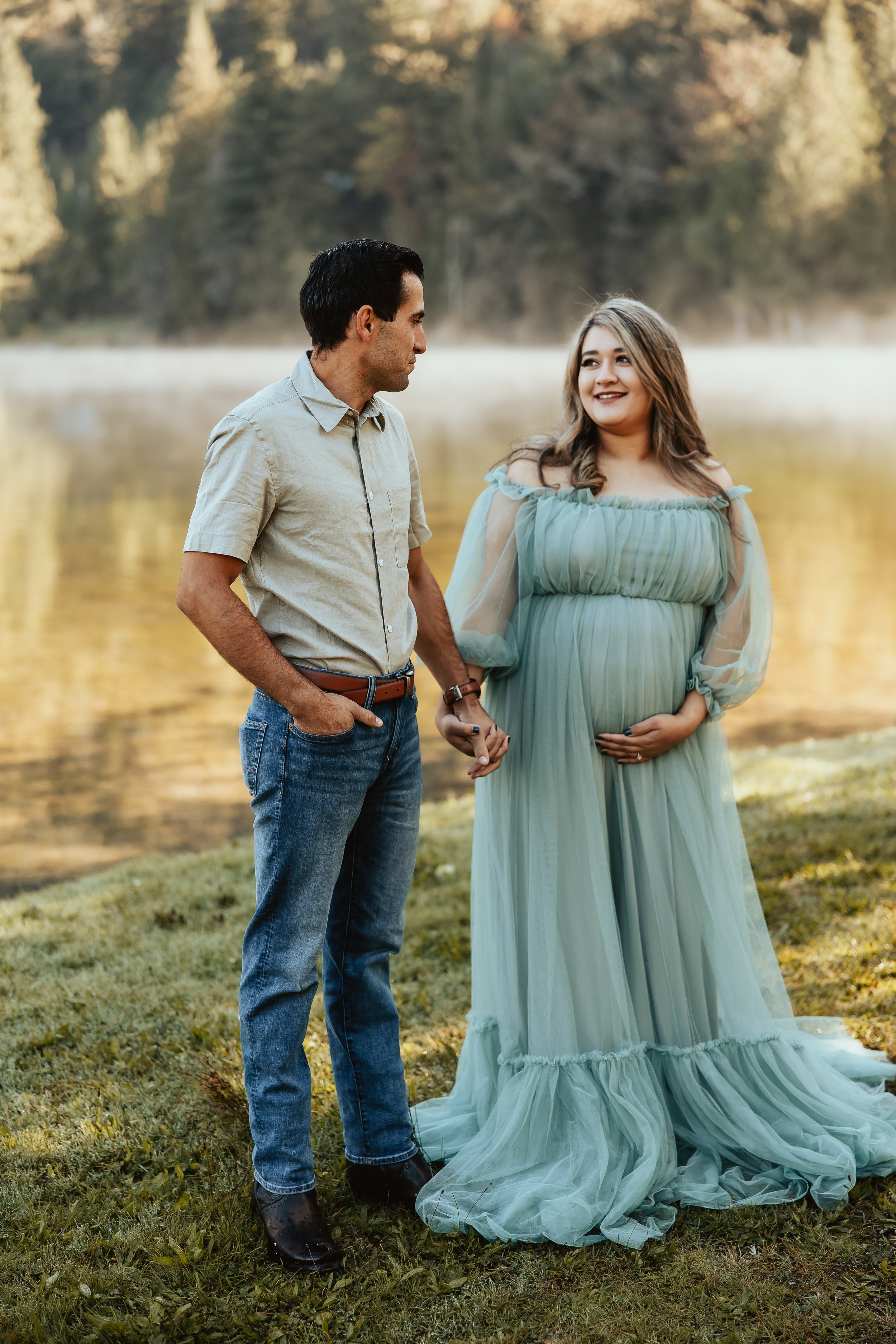 Pregnant woman smiling at husband during maternity photography session