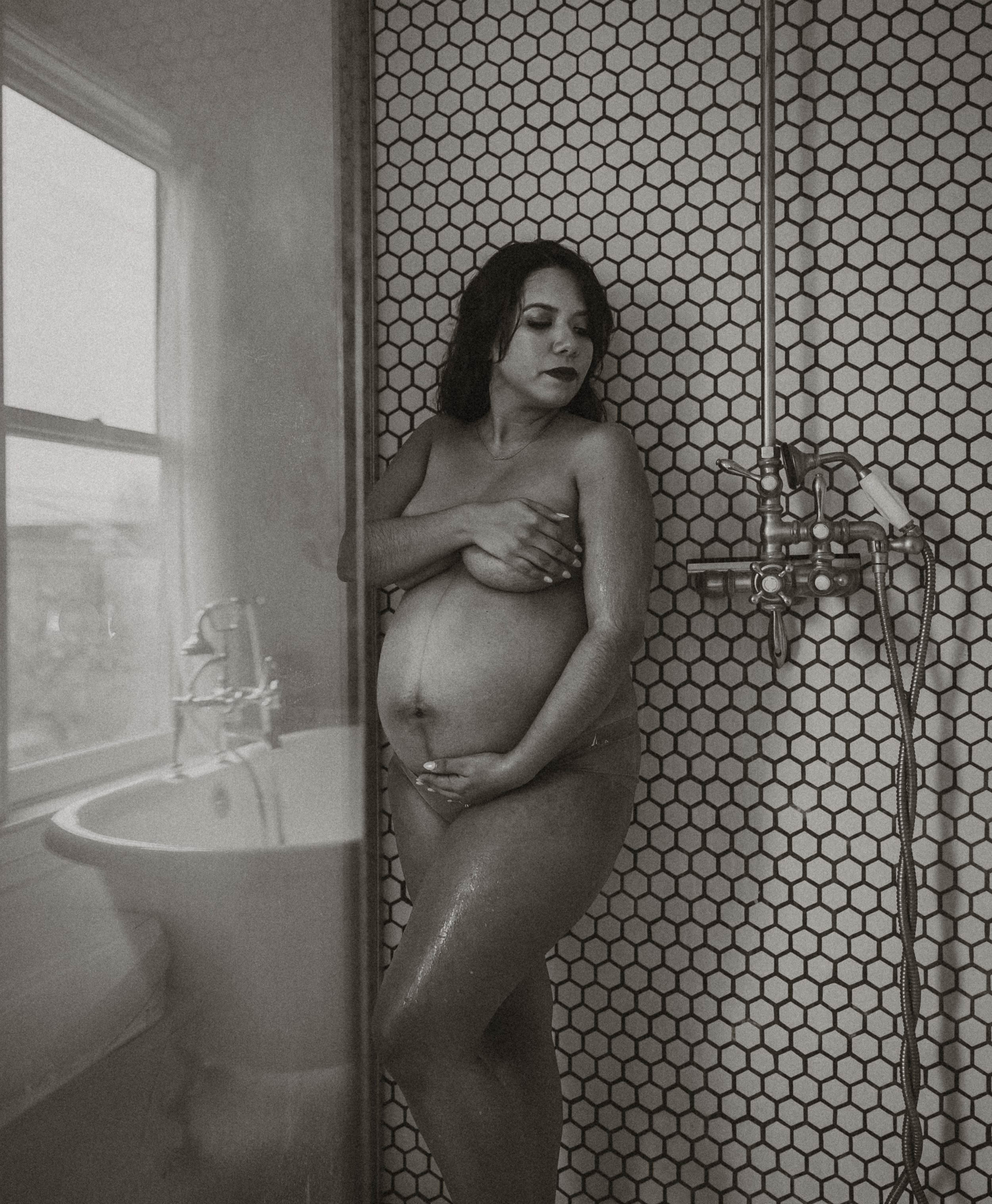 Pregnant mother in shower during maternity photography session