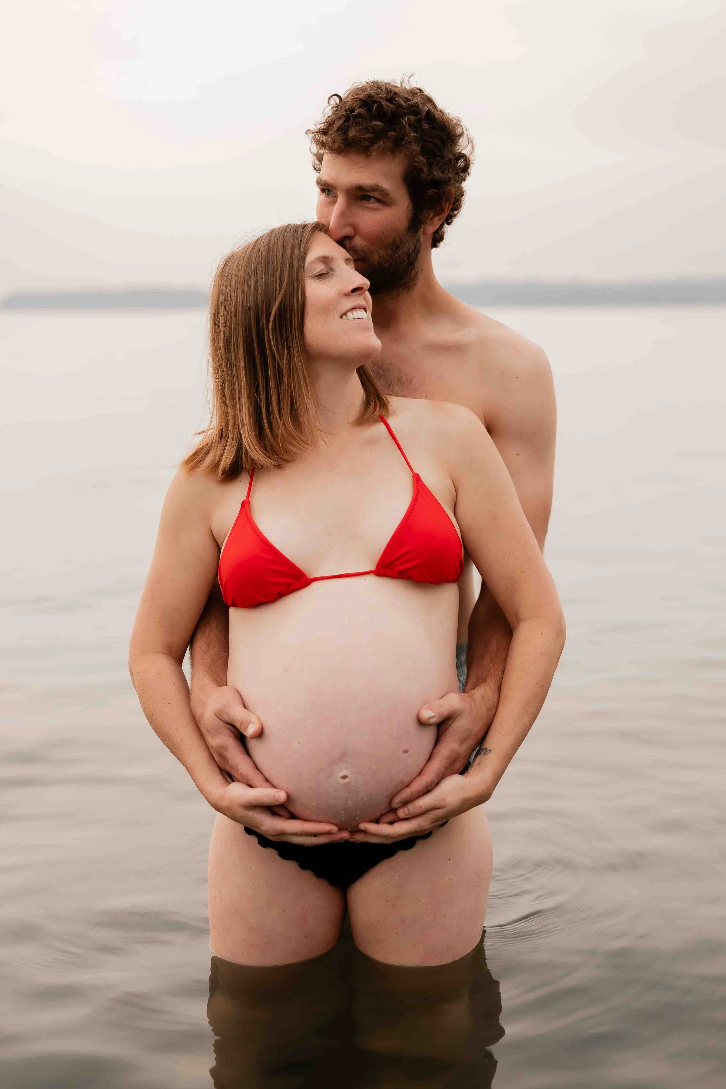 Pregnant women with husband during beach maternity session