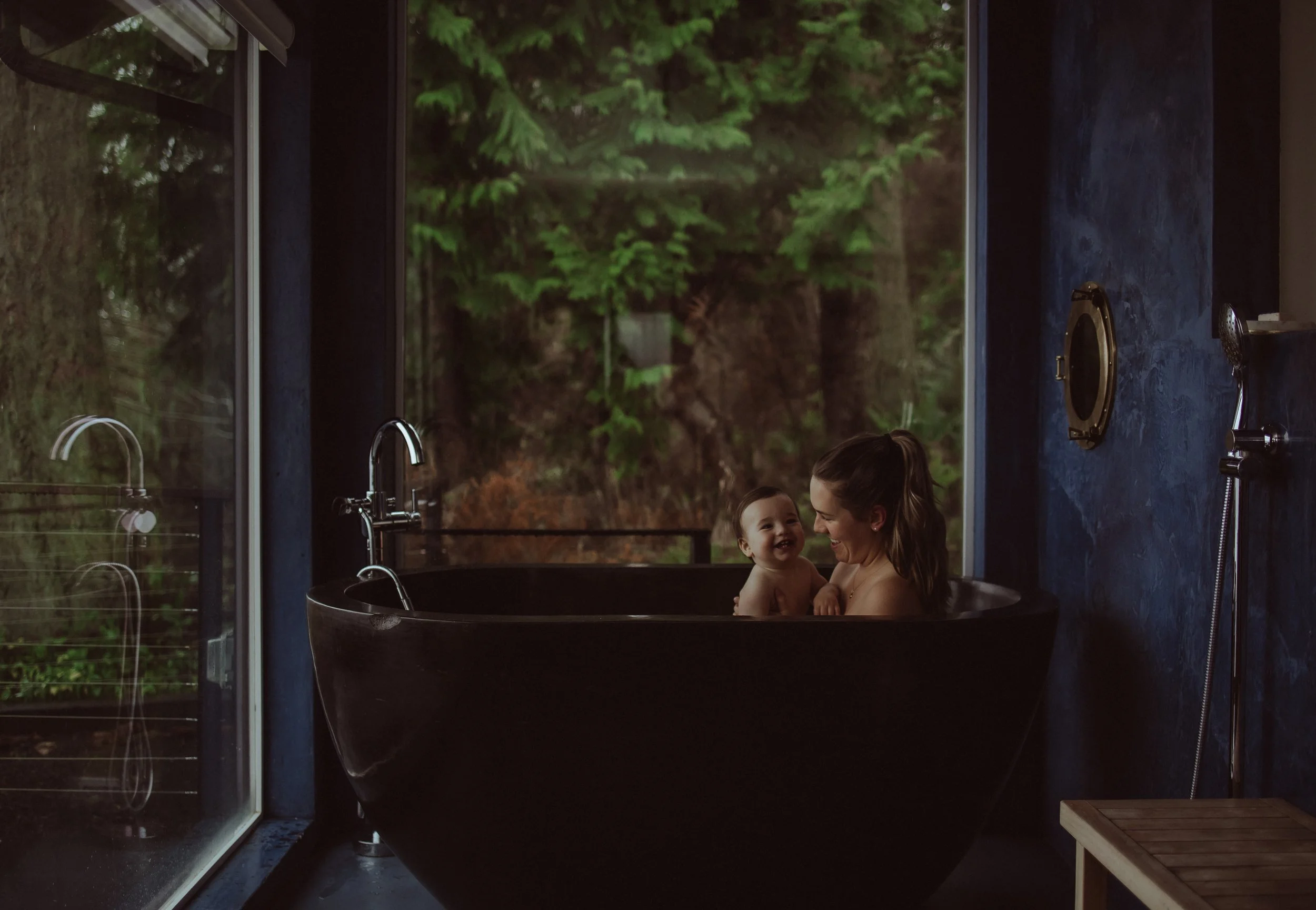 Mother and baby playing in bathtub