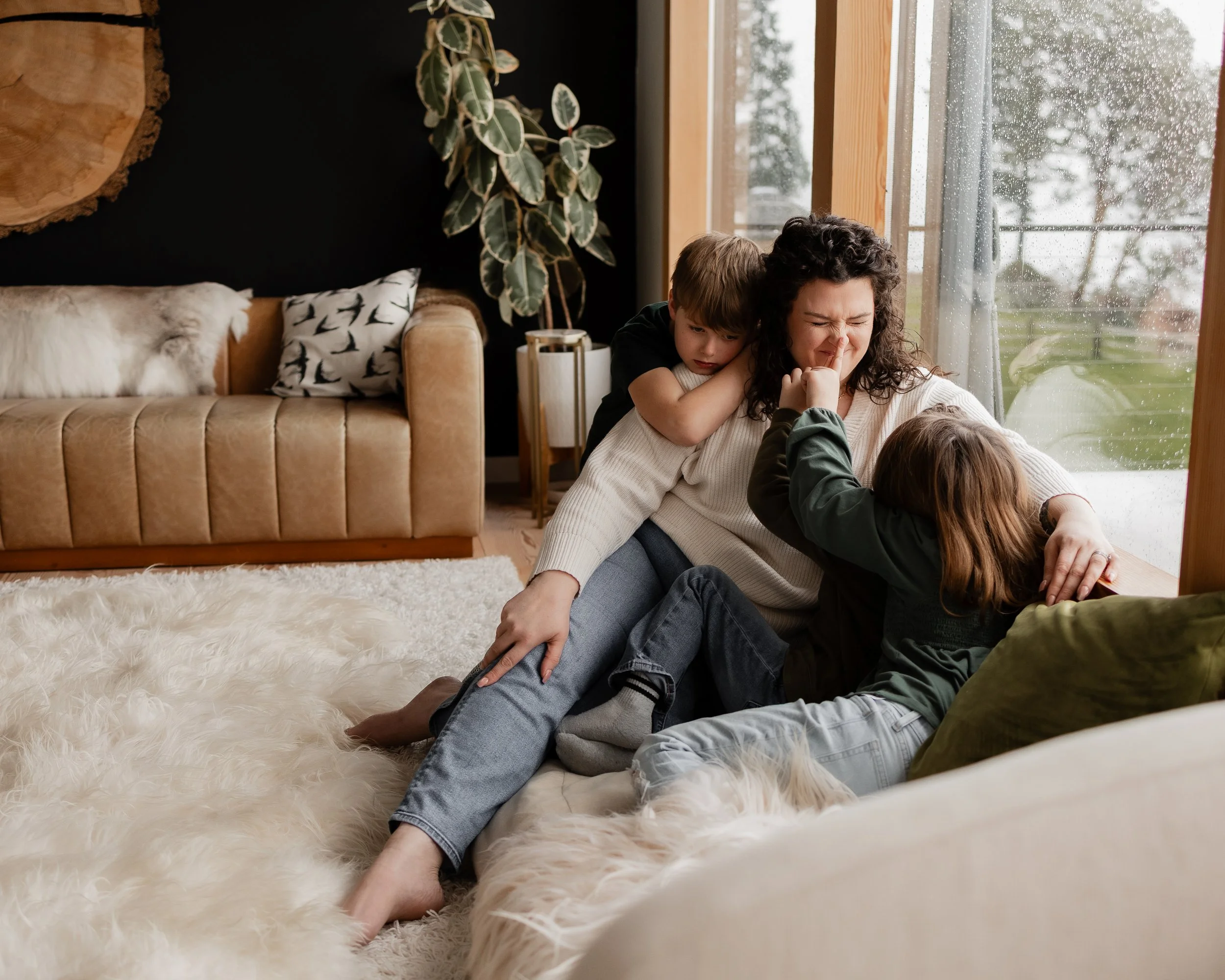 Mother playing with older children on couch 
