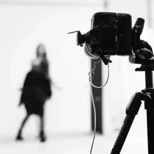 black and white photo of a camera and model at a fashion photoshoot