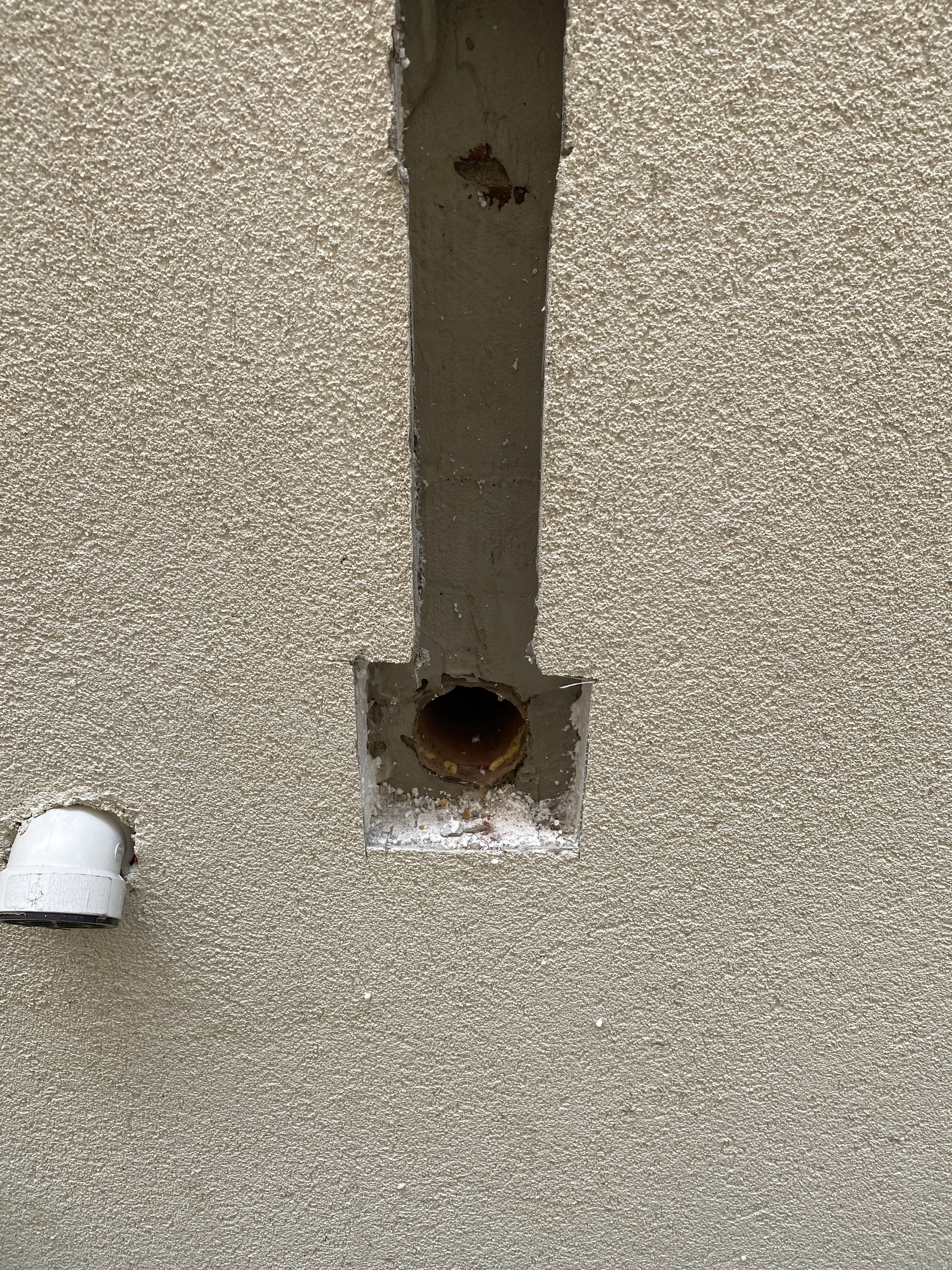 Cut and remove existing stucco around vent pipe outlets to expose connections