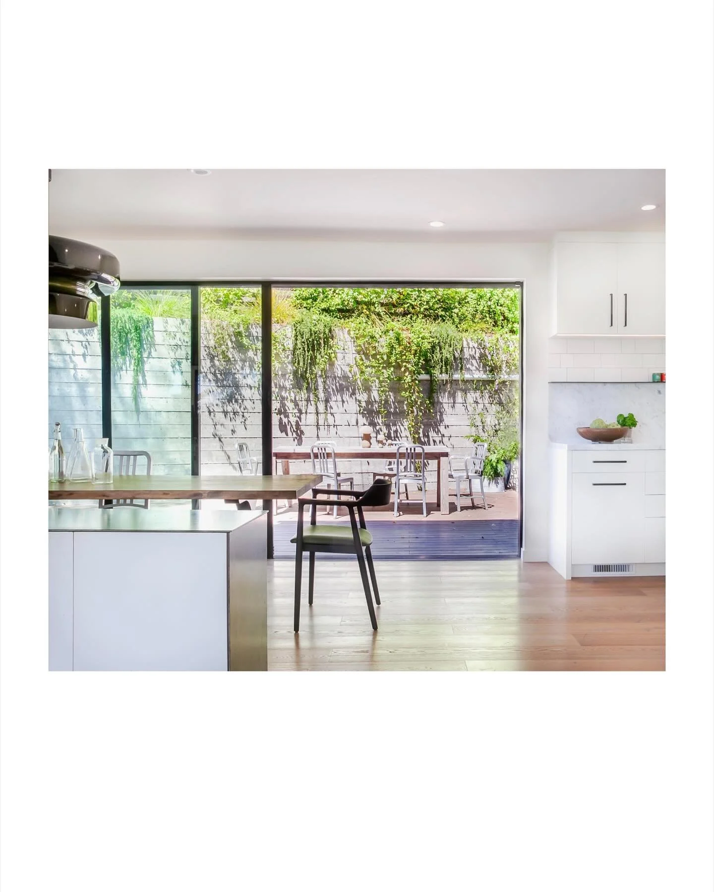 A recent dining and kitchen remodel of ours. We added a steel countertop and &ldquo;waterfalled&rdquo; the face of the cabinet with steel as well. The kitchen and dining area open to the sunny outdoor entertaining space beyond.