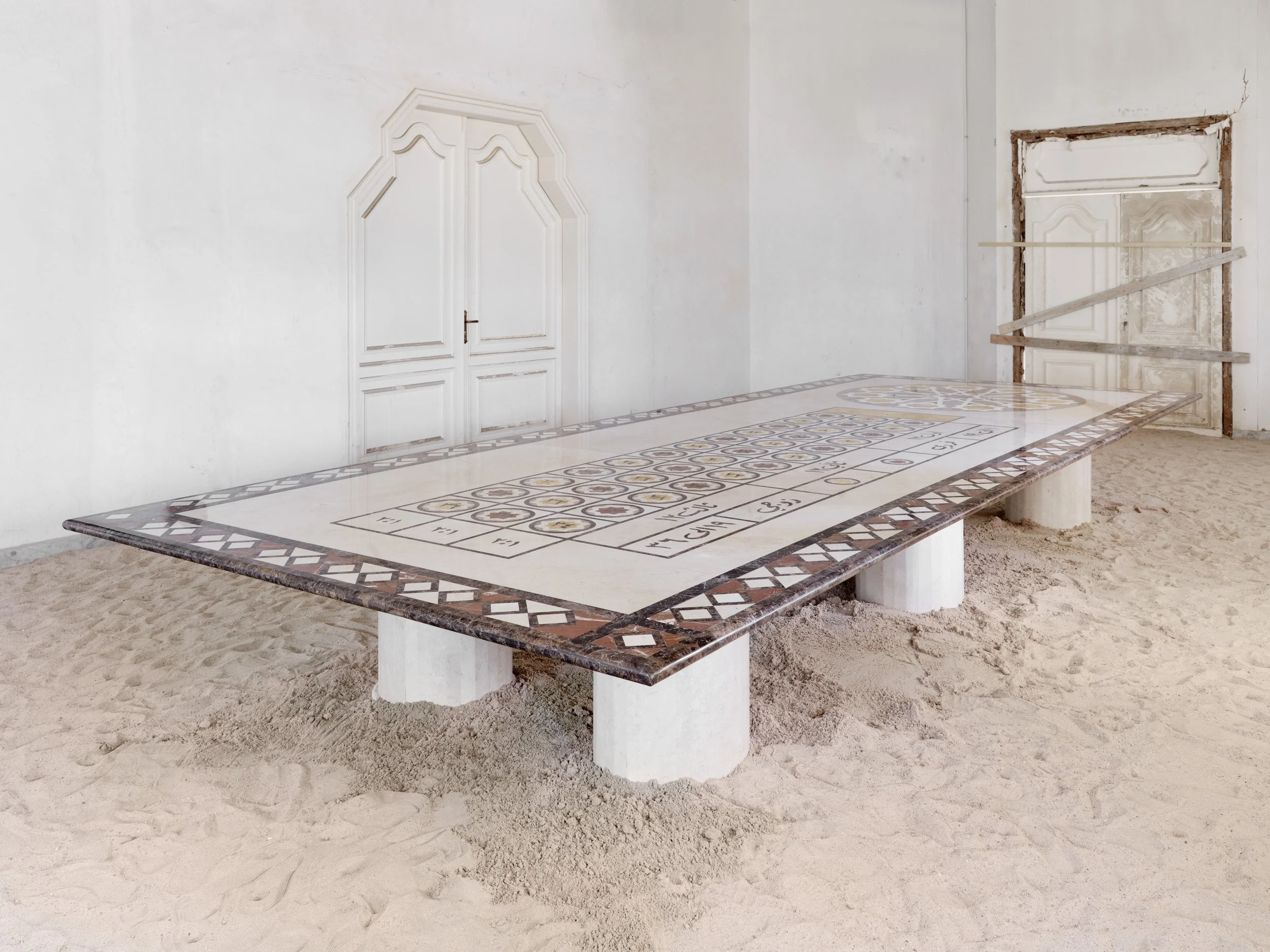 Arabic Roulette Table.
The same number sequence and table divisions are preserved. The numbers are rendered in Arabic script, and the layout reconstructed within an Arabic spatial framework. The wheel is replaced by a central geometric motif.
The cas