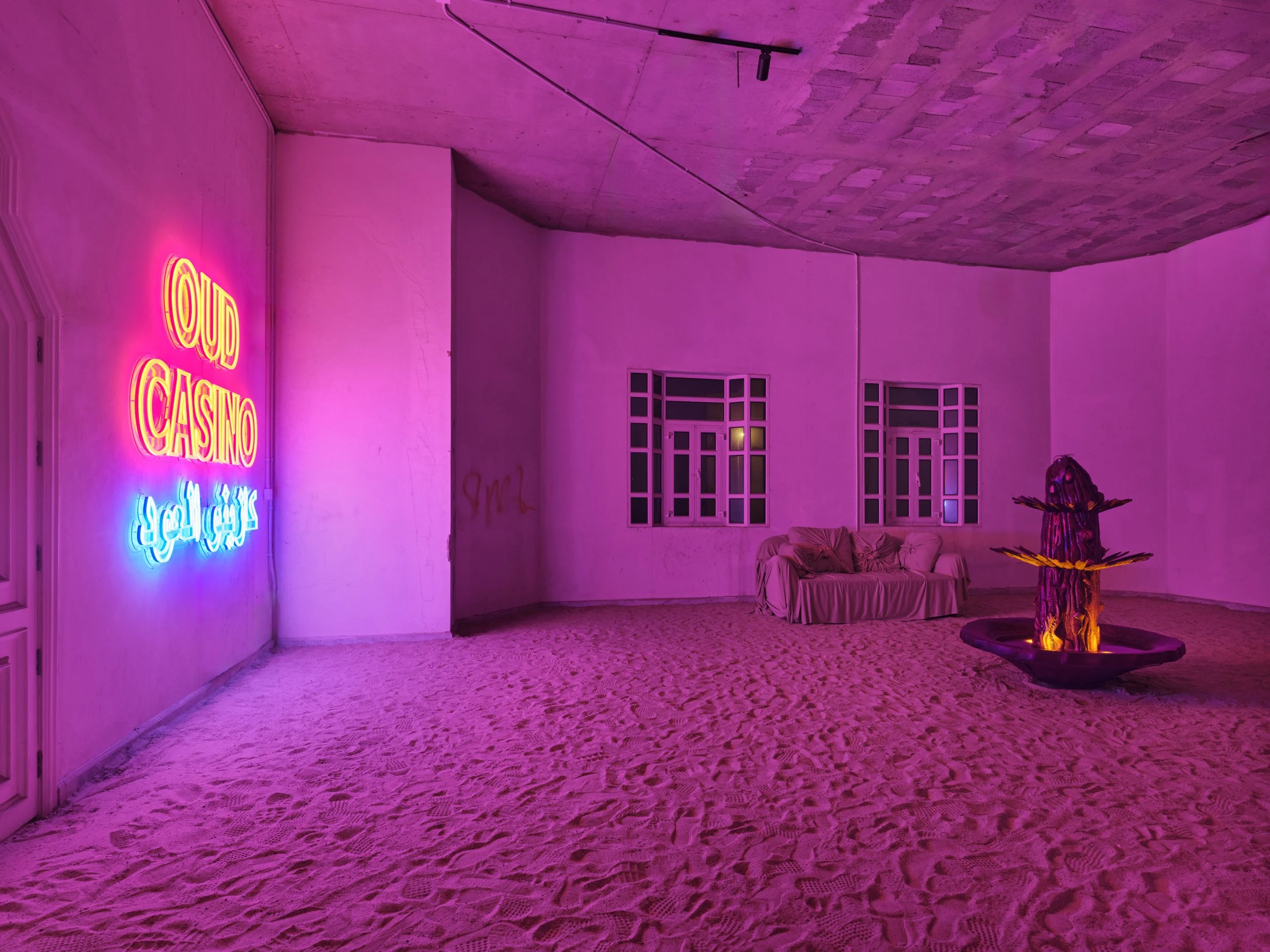 Threshold Room (Communal Transition)
To the left of the atrium, a large threshold space mediates entry into the casino.

A sofa introduces a communal condition, distinct from the seating within the casino. A fountain circulates oud oil, producing a c