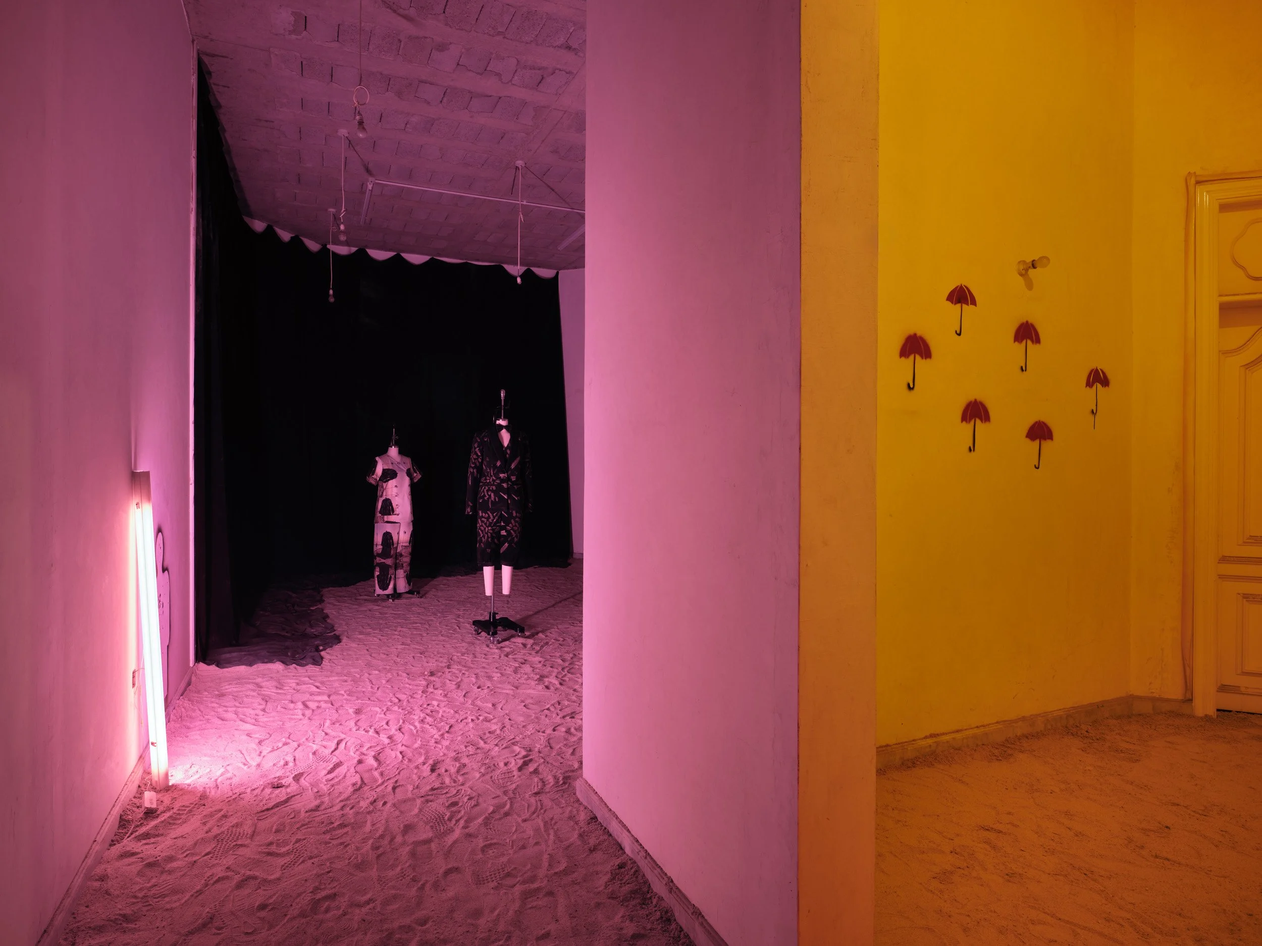 Uniform Room and Stairwell
A room where uniforms are held and assumed, functioning as a preparatory space. Red umbrellas are present as elements of protection, associated with feminine forms of safeguarding and boundary.