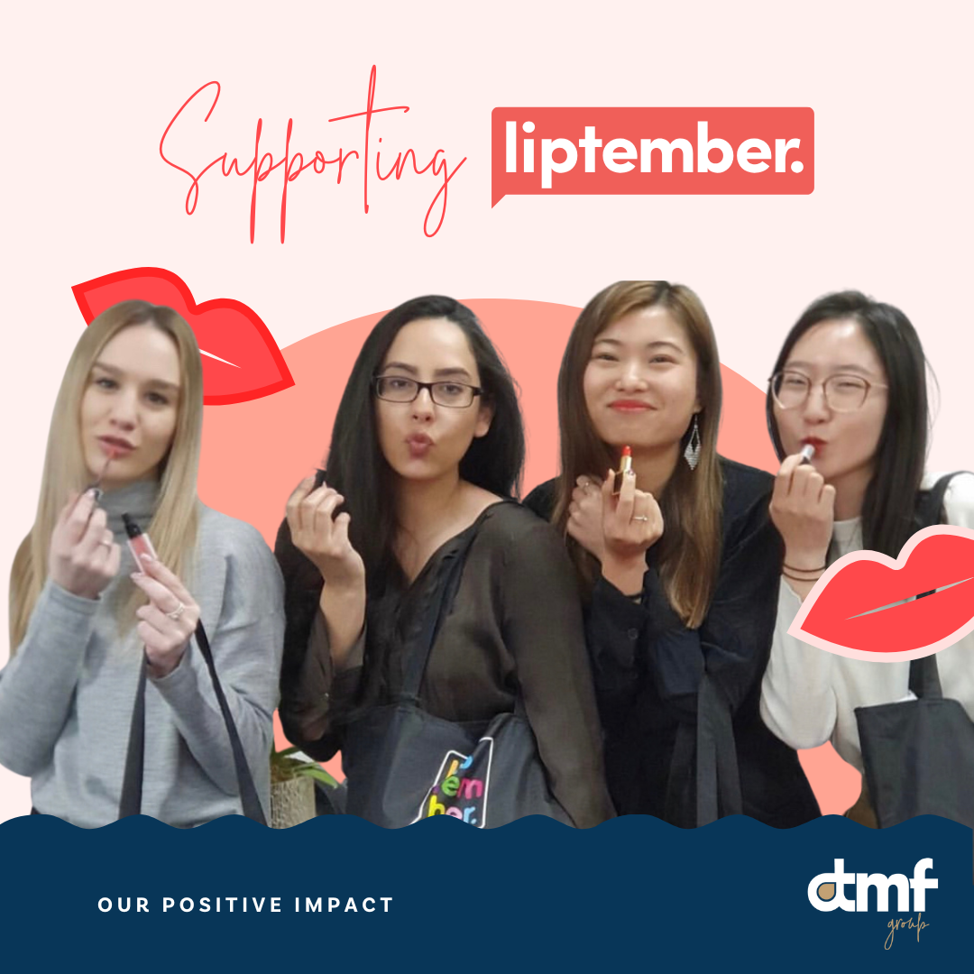Four women holding lipsticks and pretending to kiss, standing in front of a pink background with red lipstick graphics, supporting 'Liptember' in September, promoting awareness for positive impact.