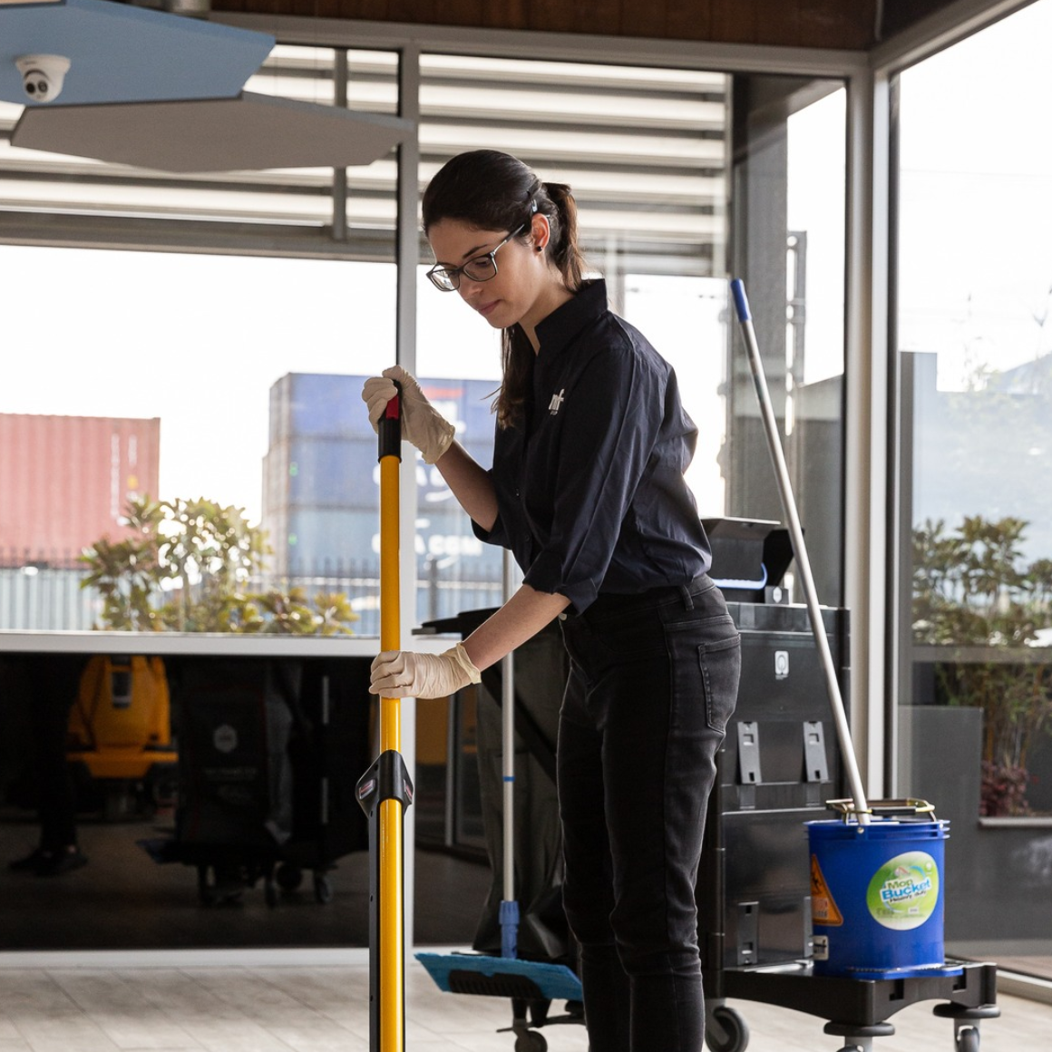 Woman cleaning the floor with a mop in an indoor setting.