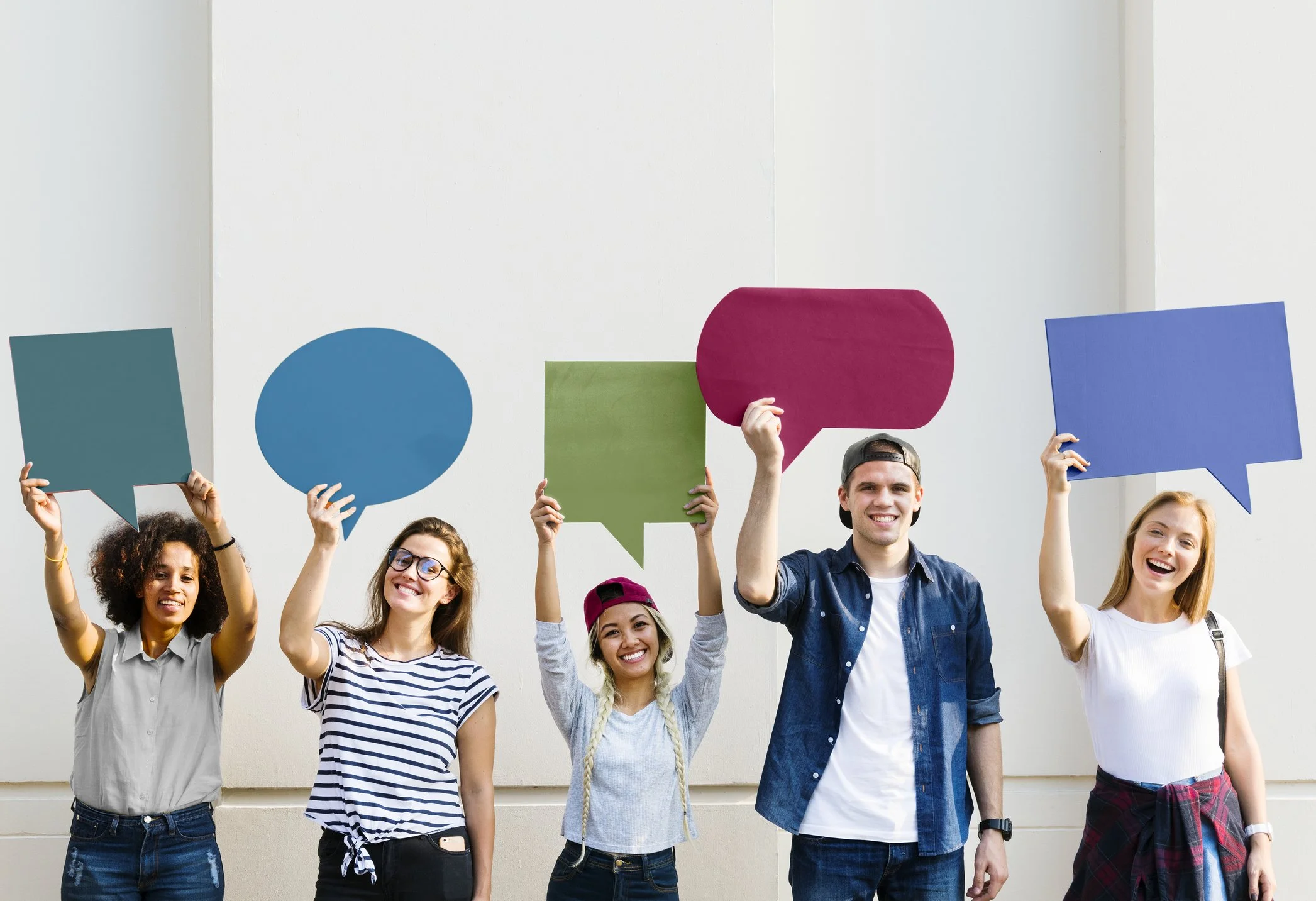 Group of students holding up coloured speech bubbles to signify student voice