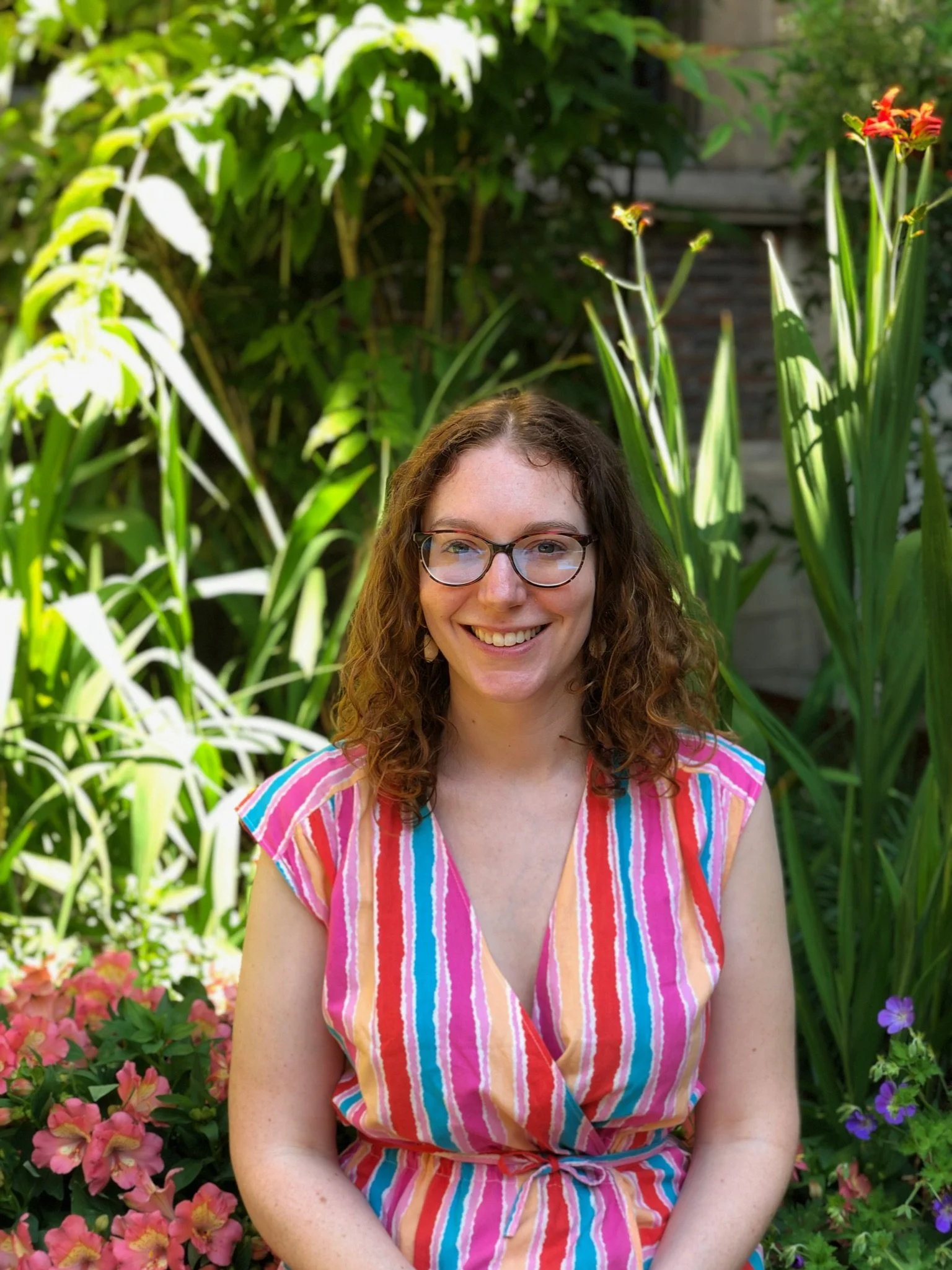 Smiling Marianne in a colourful dress sitting in a garden