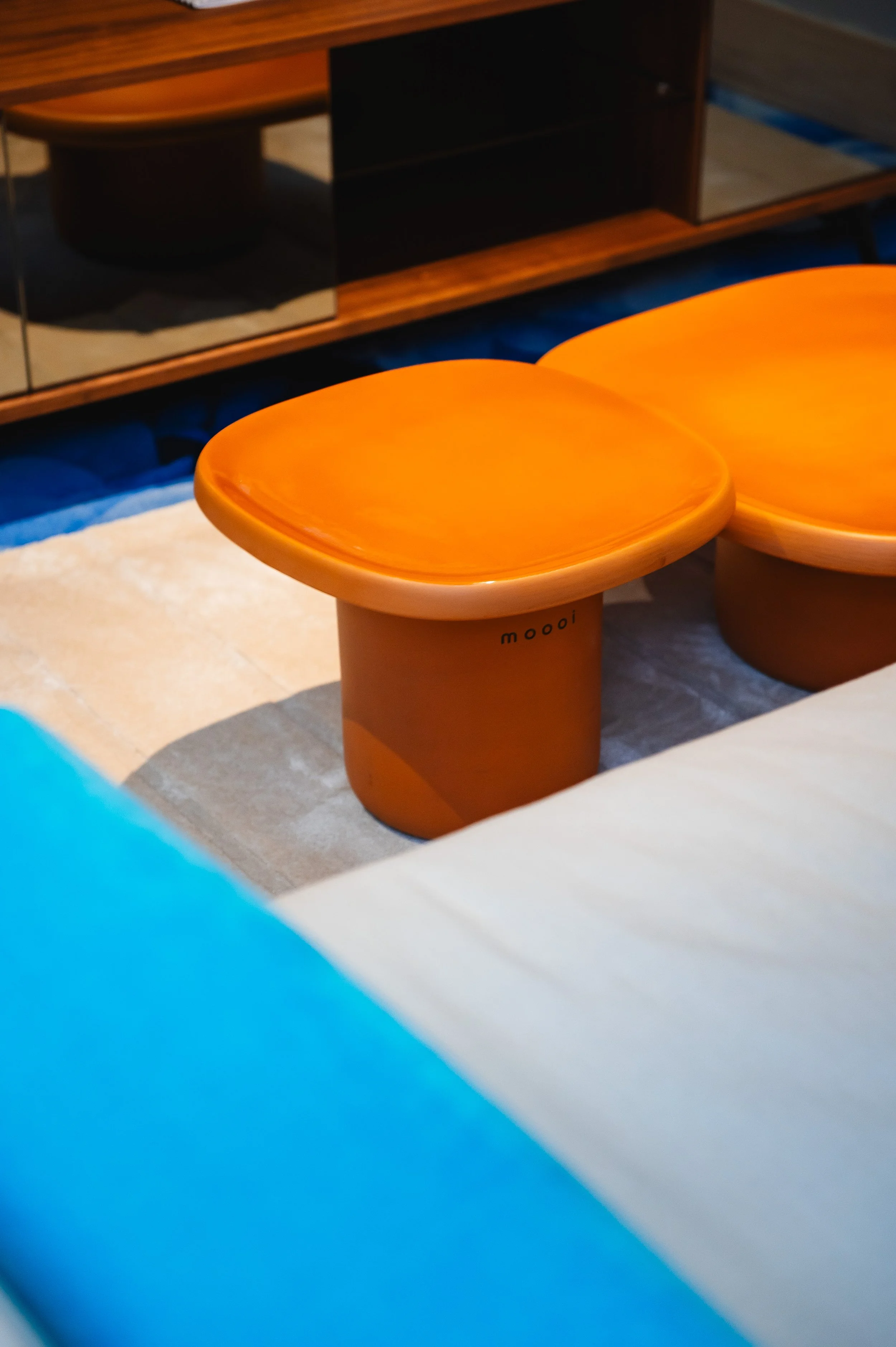 Mesa naranja de madera pulida en un espacio interior.