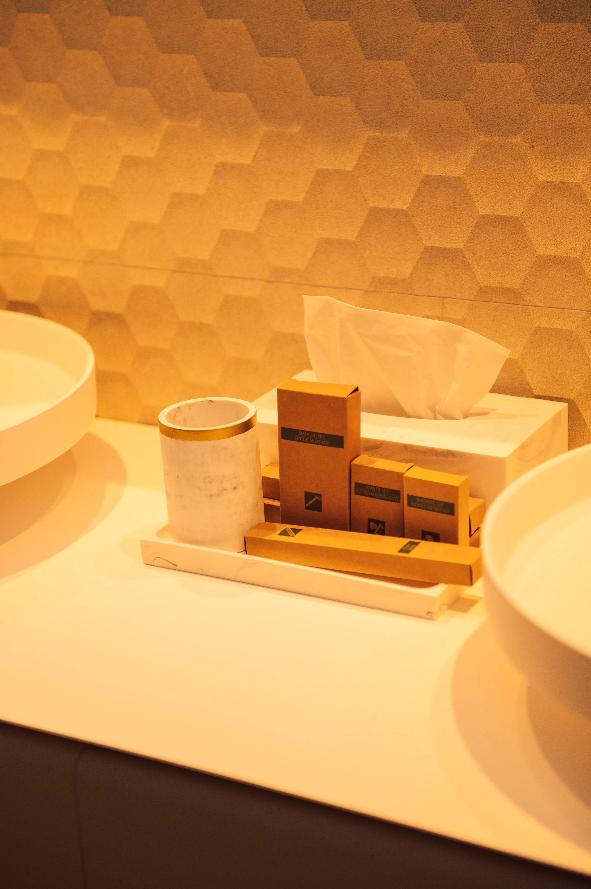Caja con artículos de aseo, papel tissue y tazas blancas en un con interior.»