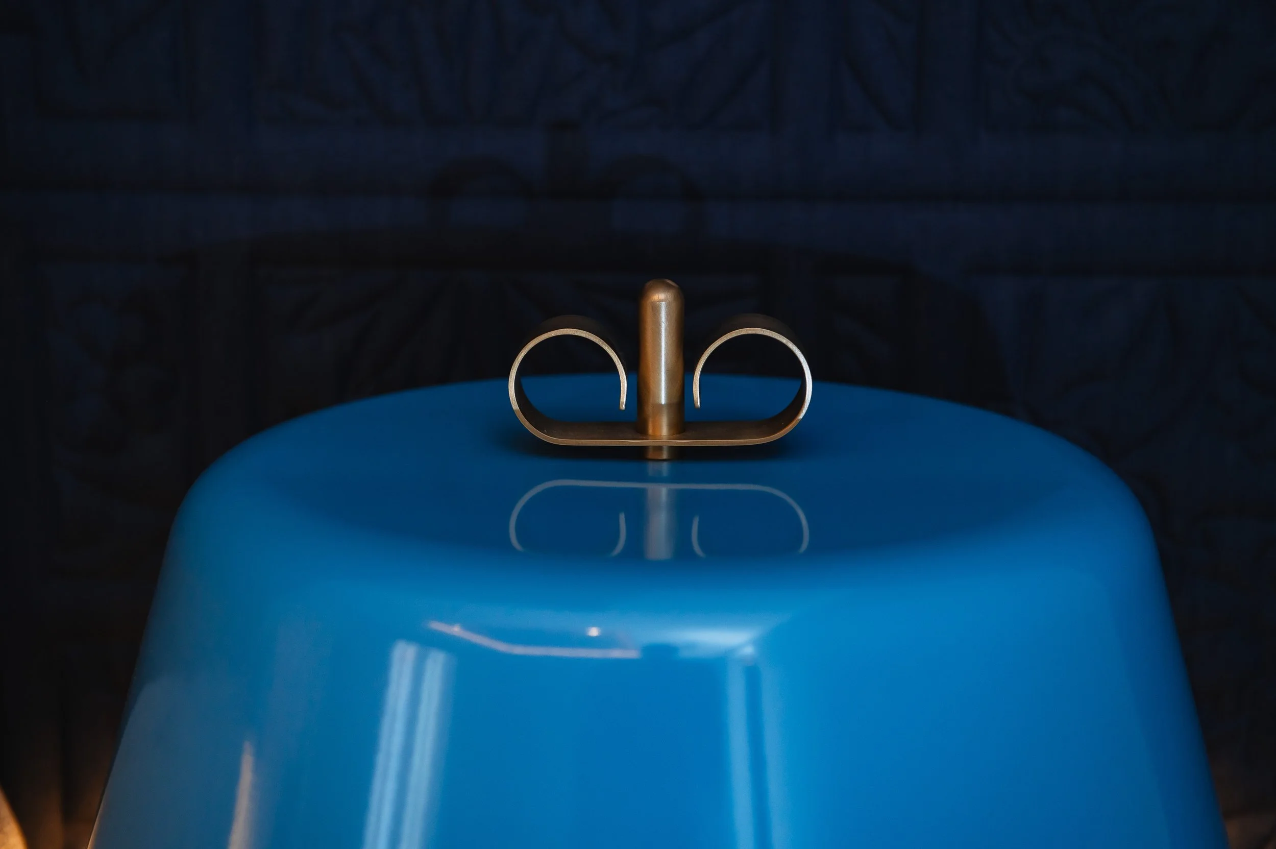 Cuchara de madera sobre un recipiente azul, reflejada en su superficie