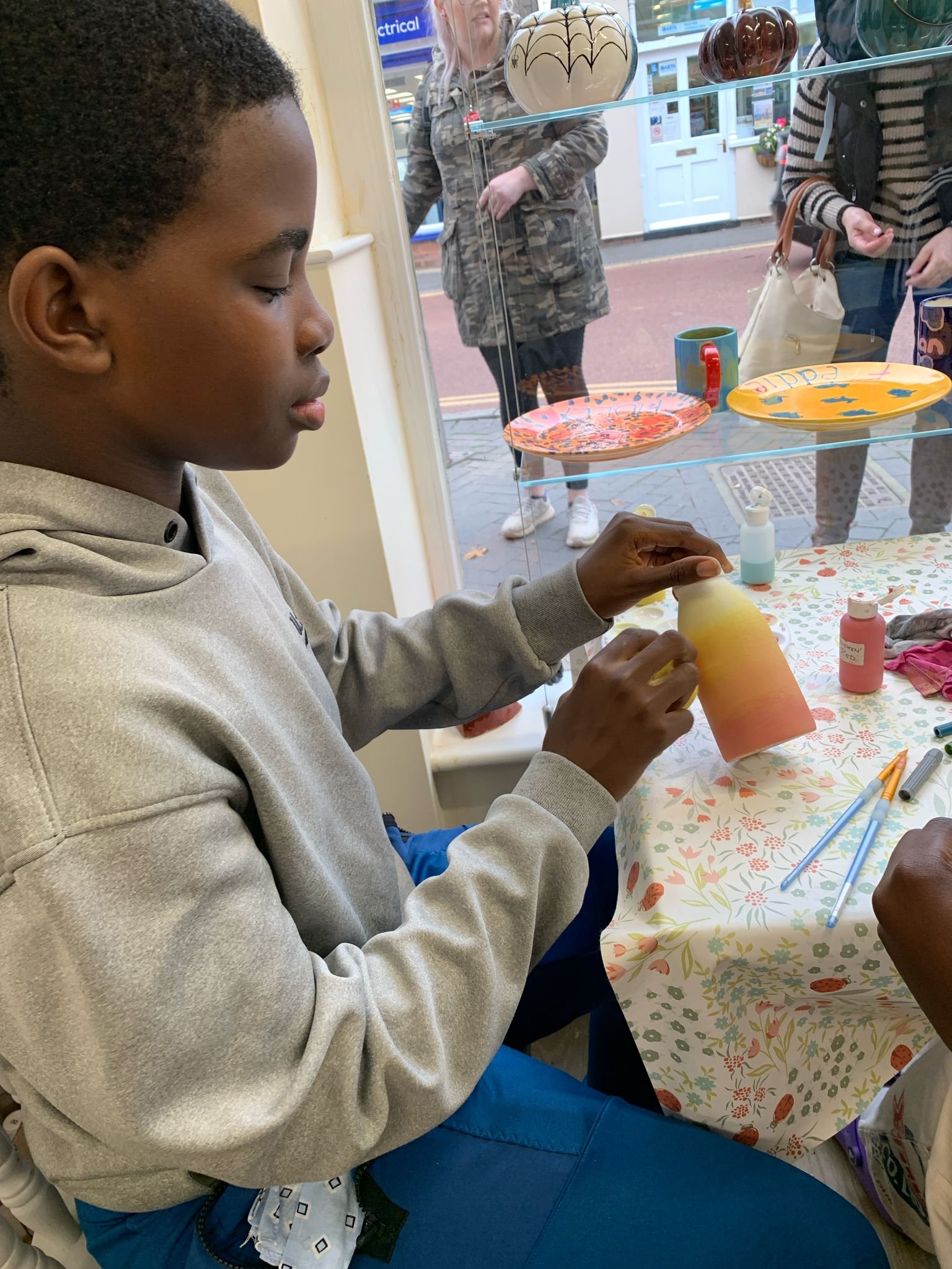 pitter potter - boy painting pot.jpeg