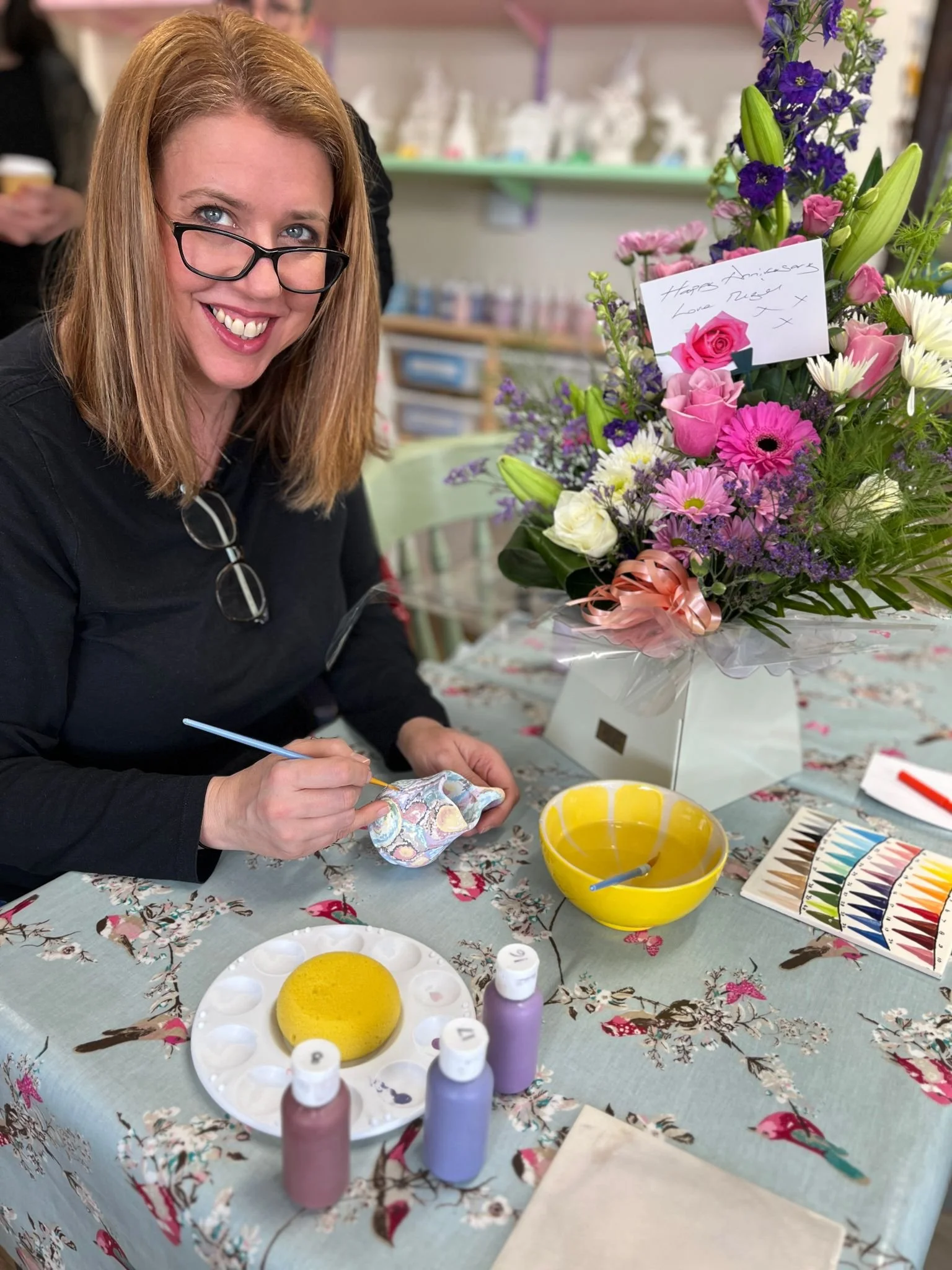 women smiling as she paints pot.jpeg