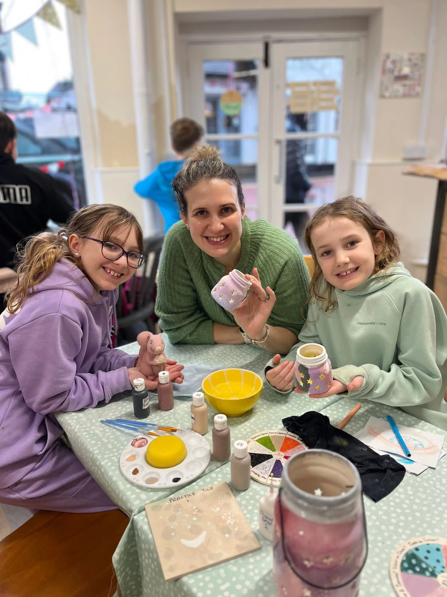 mother and two daugters painting pots smilubg.jpeg