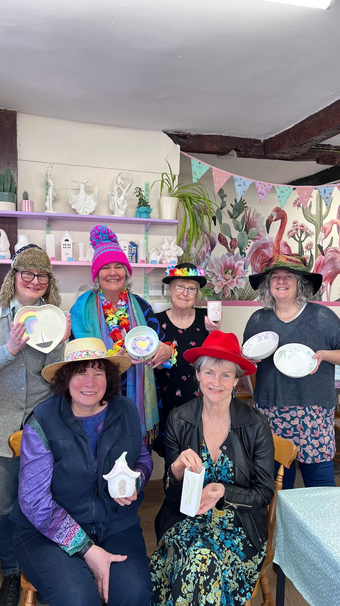 group of women in hats holding painted plates..jpeg
