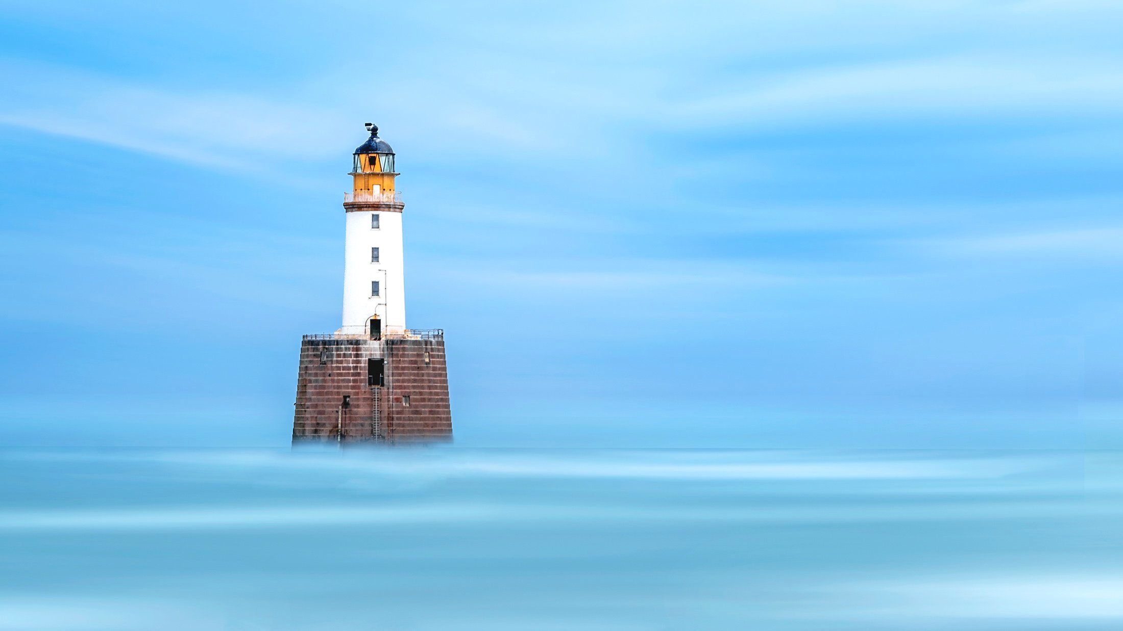Rattray Head Lighthouse standing offshore in the North Sea near Aberdeenshire, Scotland.