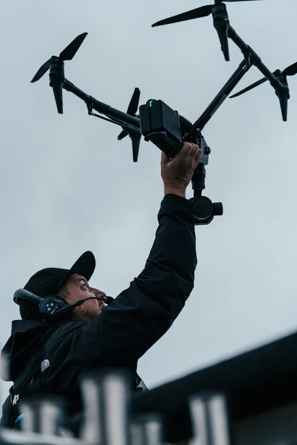Jan Pavelka holding a large drone, wearing a headset