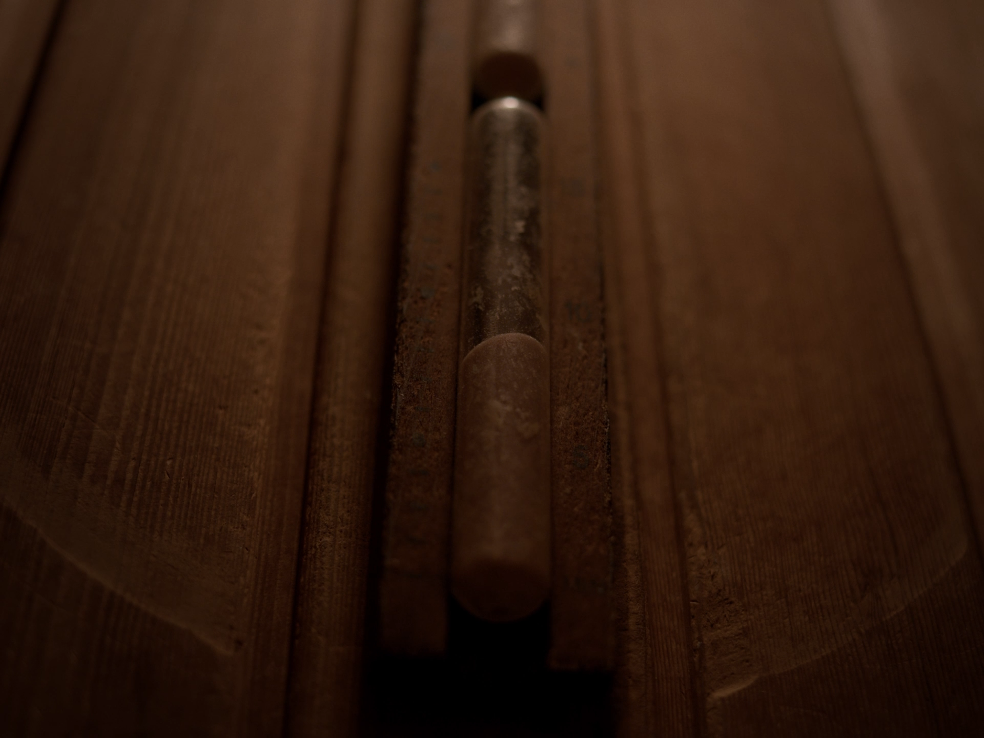 Nahaufnahme eines rustikalen Türgriffs aus Metall an einer Holztür.