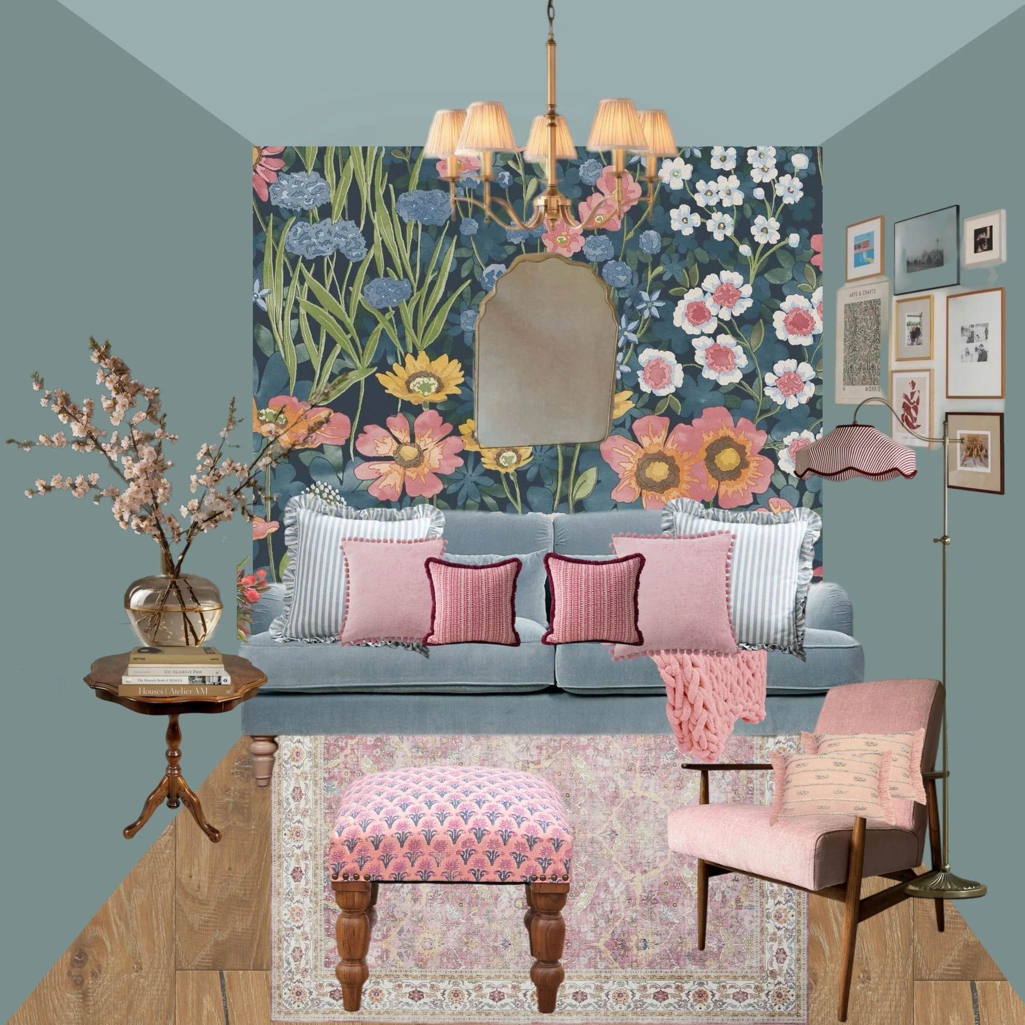 A cozy living room with a floral wallpaper background, a blue sofa with pink and striped pillows, a side table with a vase of flowers, a pink patterned ottoman, a pink armchair with a pillow, wall art, and a chandelier overhead.