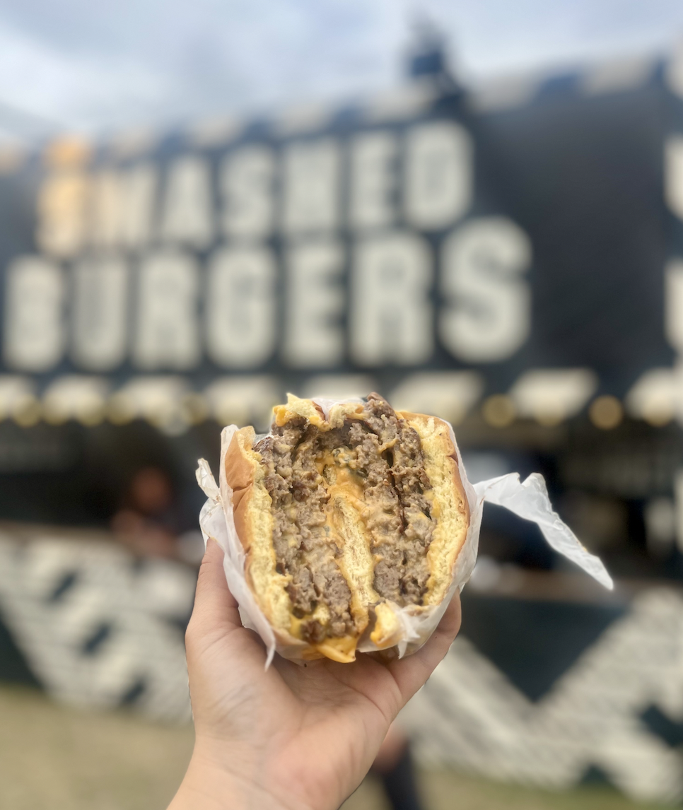 Juicy smashburger outside Crooked Kitchen's Smash & Grab Burger music festival catering stall