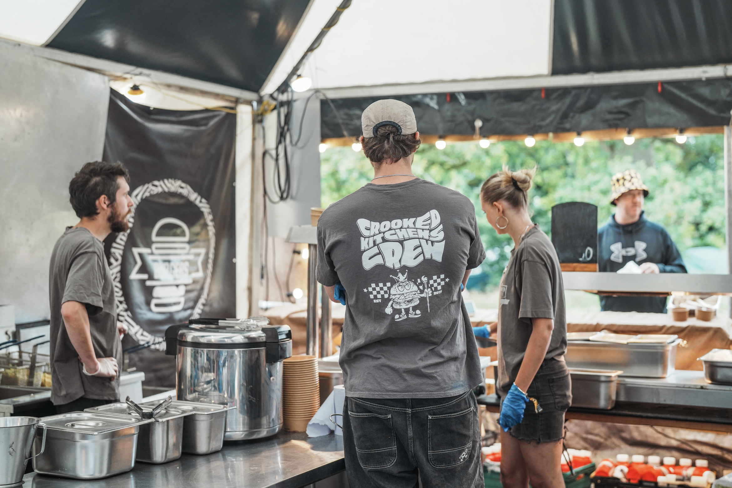 Staff wearing branded Crooked Kitchens graphic design t-shirt inside the smashburger stall