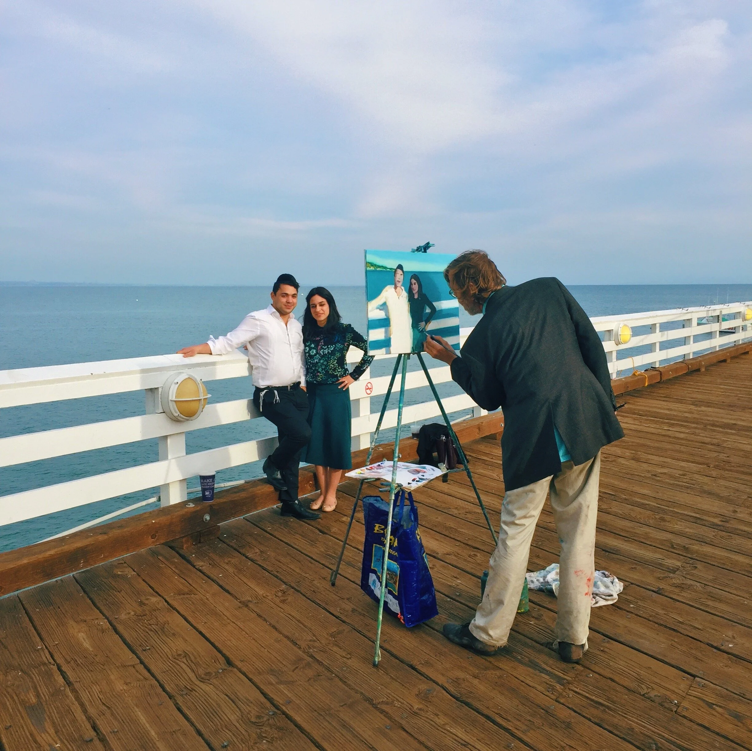 Young Jewish couple being painted on the Malibu pier in Los Angeles