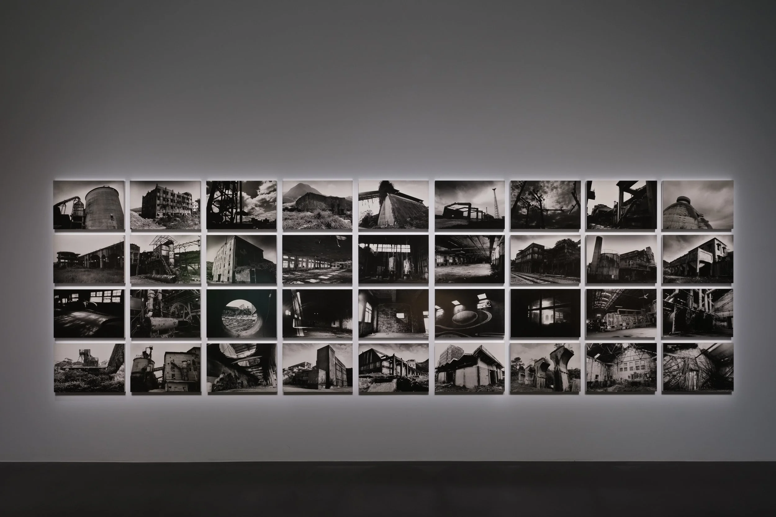 A wall of black and white photos of ruins