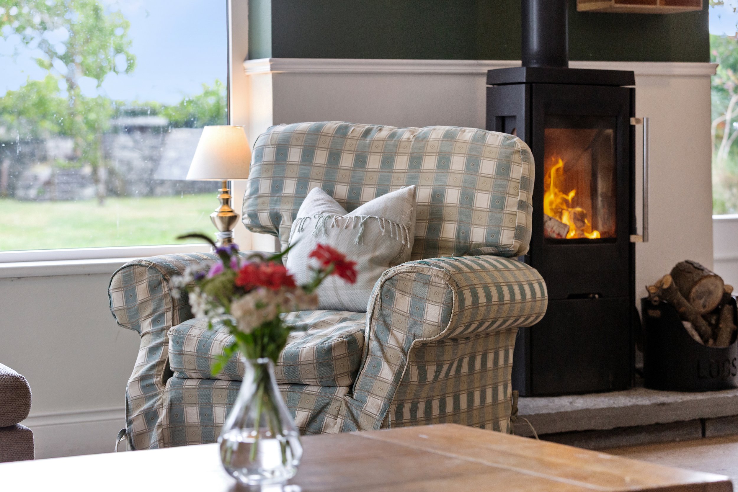BY THE FIRE 
A cosy corner beside the wood-burning stove - especially welcome after a day outdoors.

