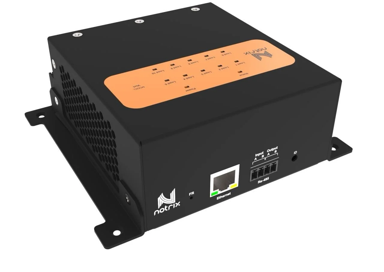 Black electronic device with orange panel on top, various ports and connectors on front, and ventilation holes on sides.