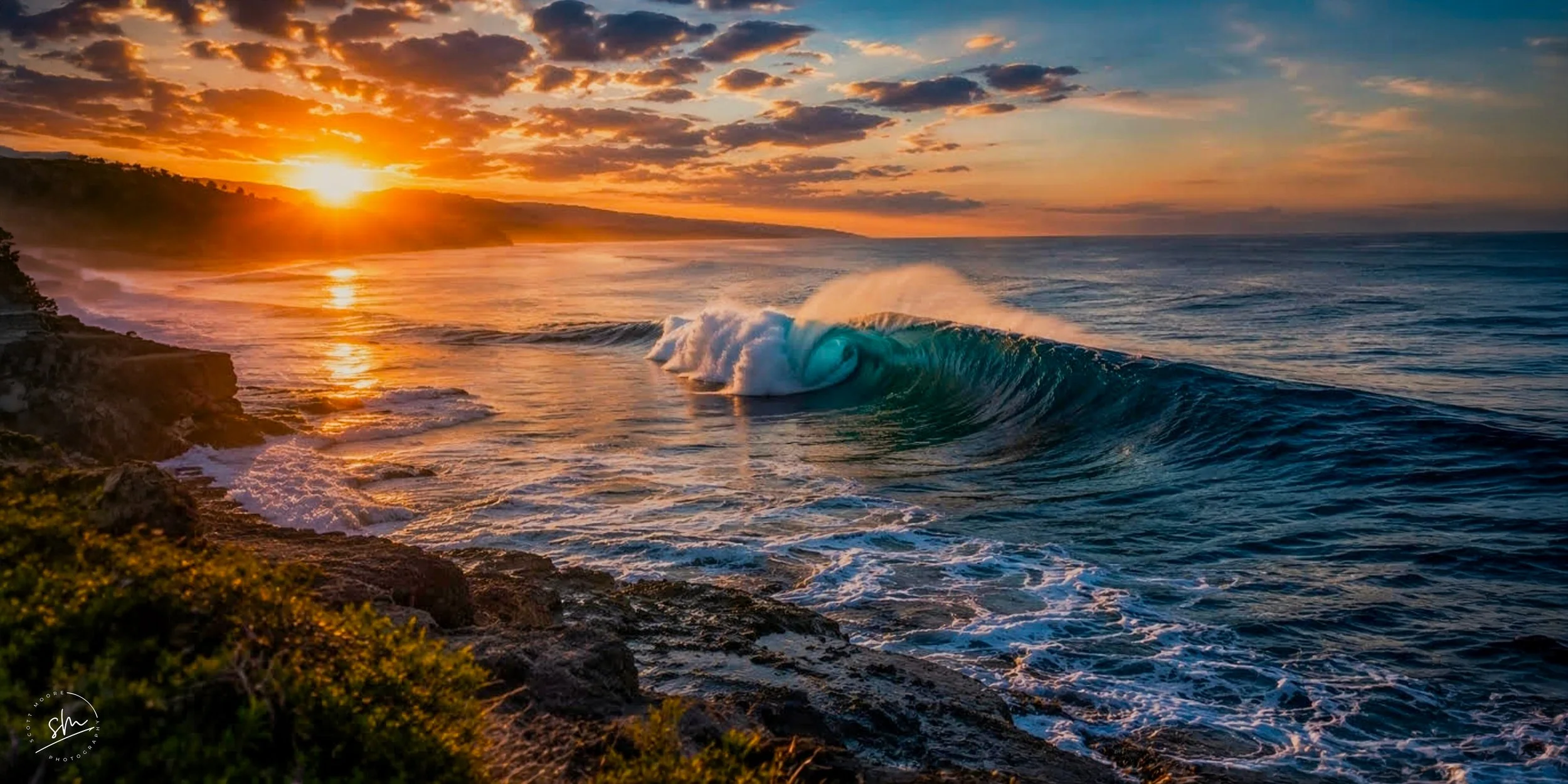 Sunset over the ocean with waves crashing against rocks, clouds in the sky, and a warm orange glow from the setting sun.