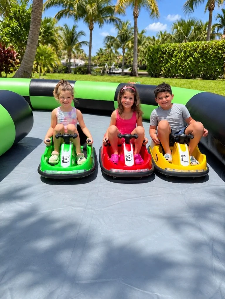 Three kids smiling in ride-on bumper cars