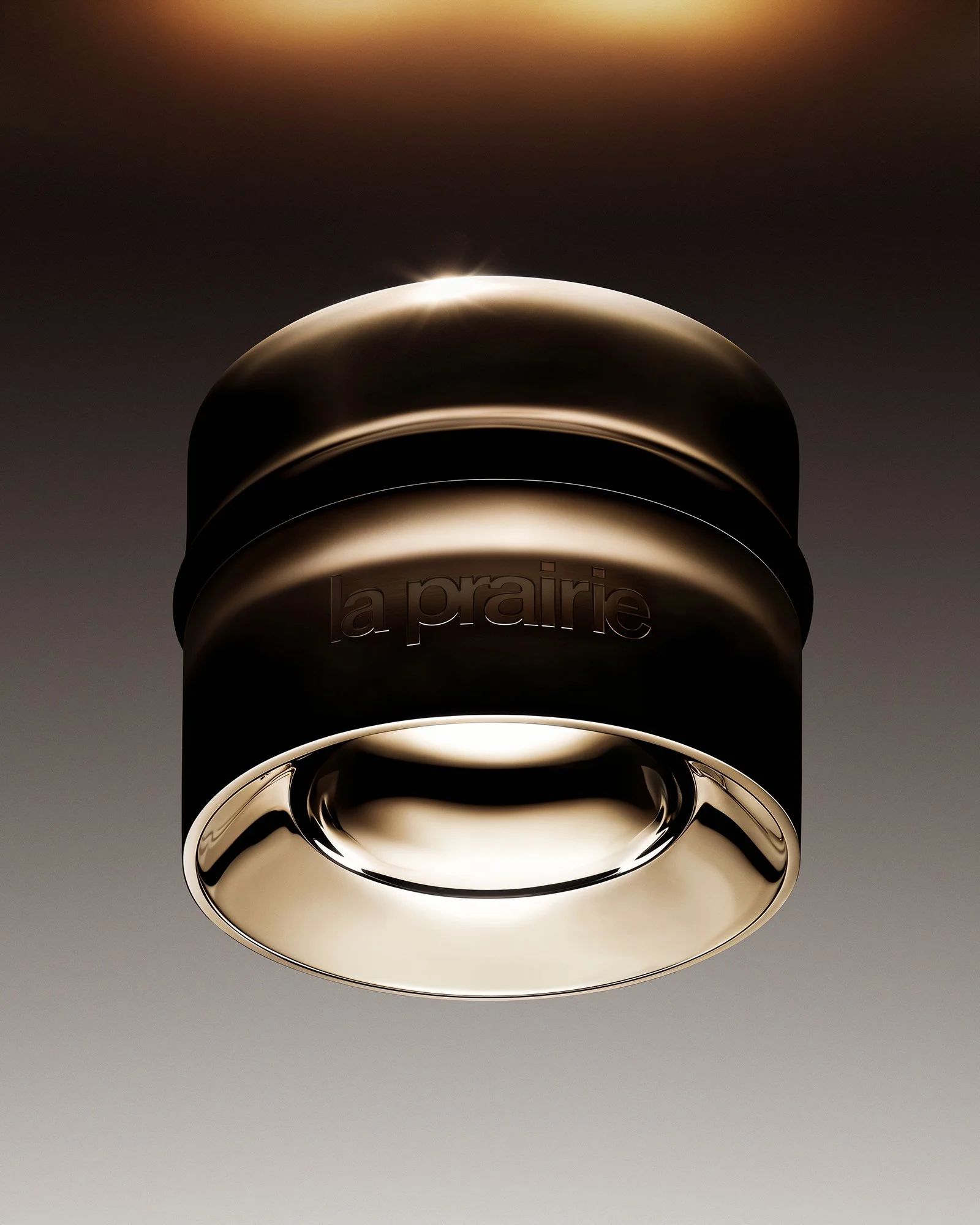 A shiny, metallic ceiling light fixture with the brand name 'la prairie' embossed on it, viewed from below against a neutral background.