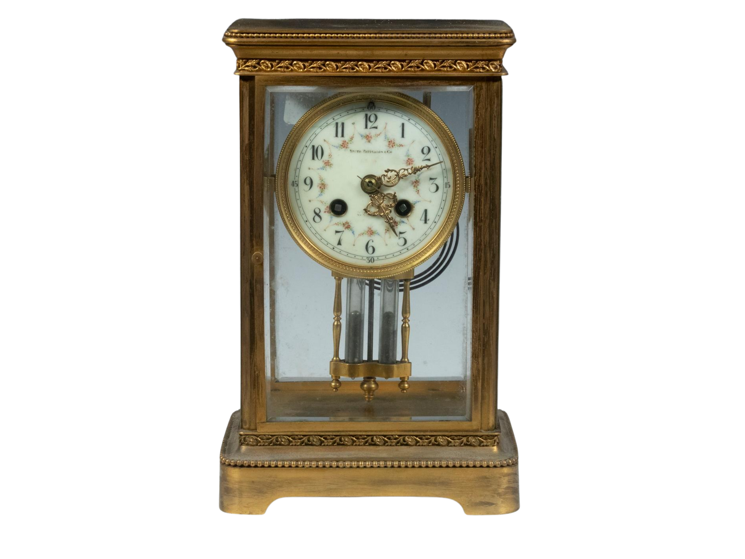 An antique brass and glass mantel clock, featuring a white clock face with black numbers, and ornate brass clock hands - Lot 3086 in the Cabin Fever auction on January 23rd.