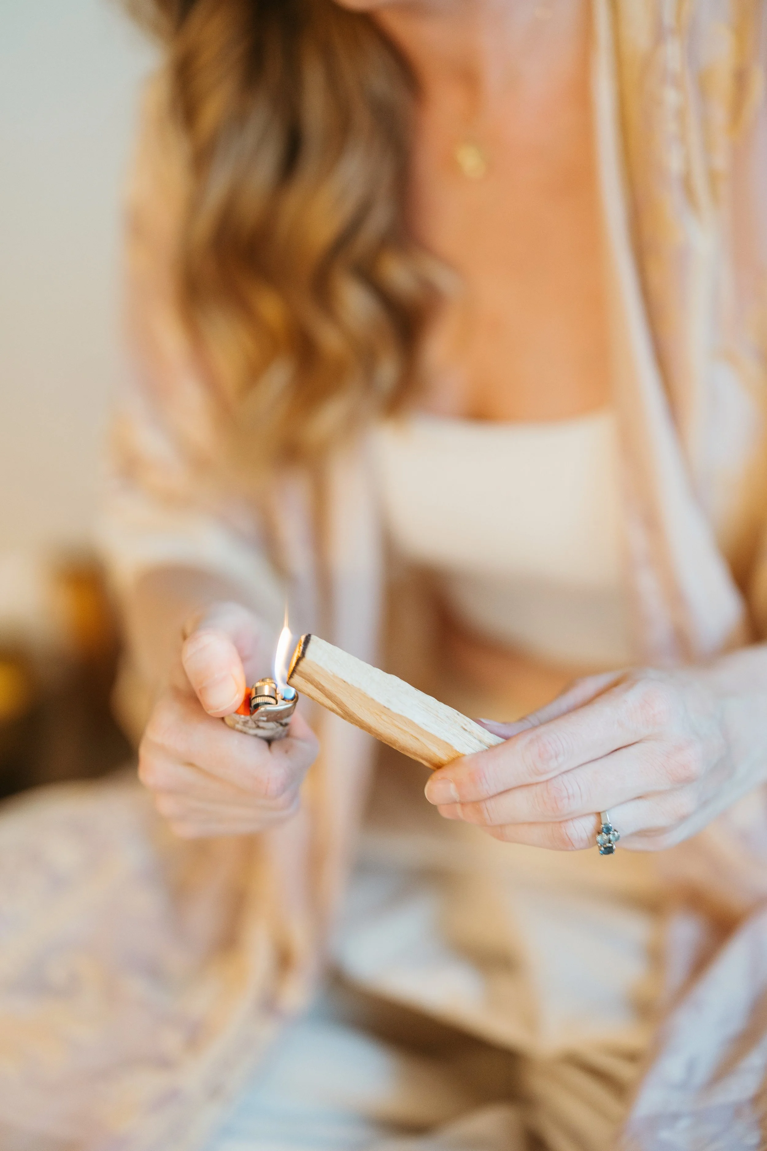 Person holding a lighter to a small piece of wood