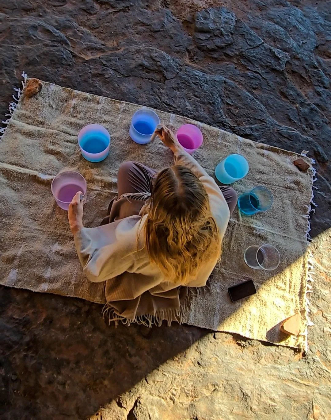 Woman playing crystal singing bowls in Sedona, sound healing.