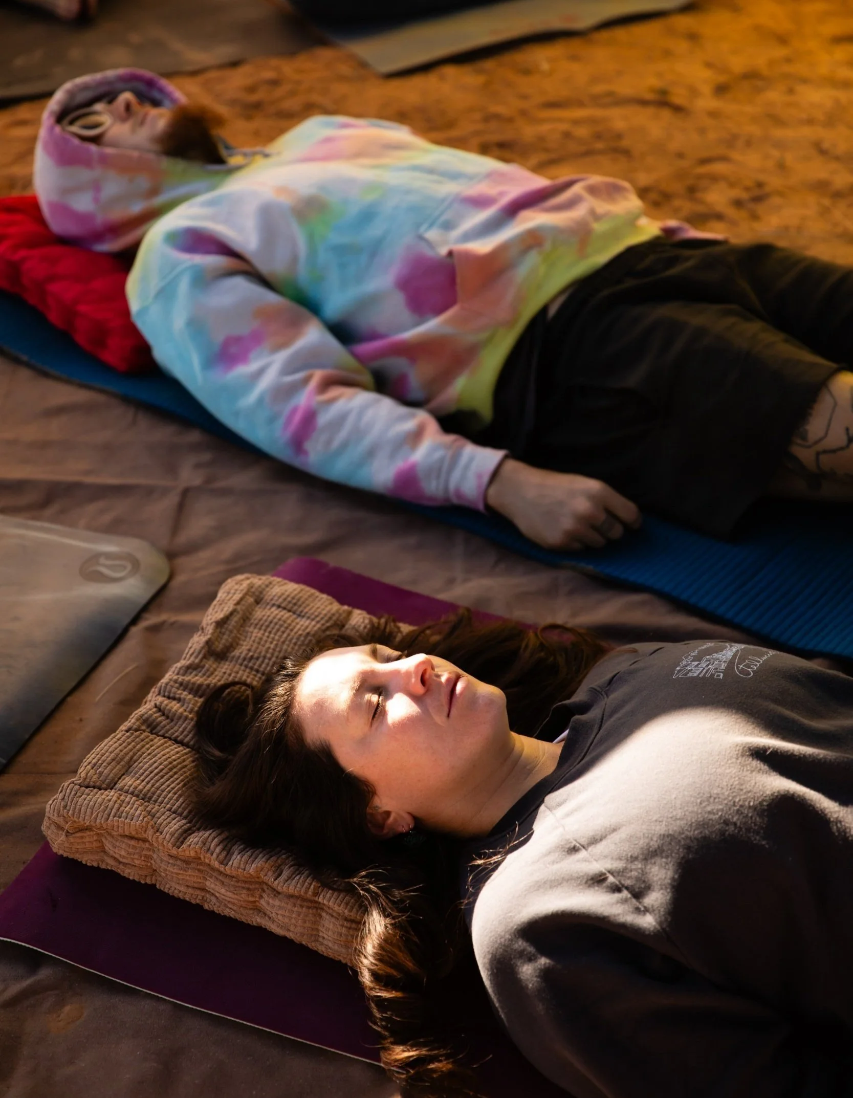 Two participants looking serene attending a sound bath at a festival