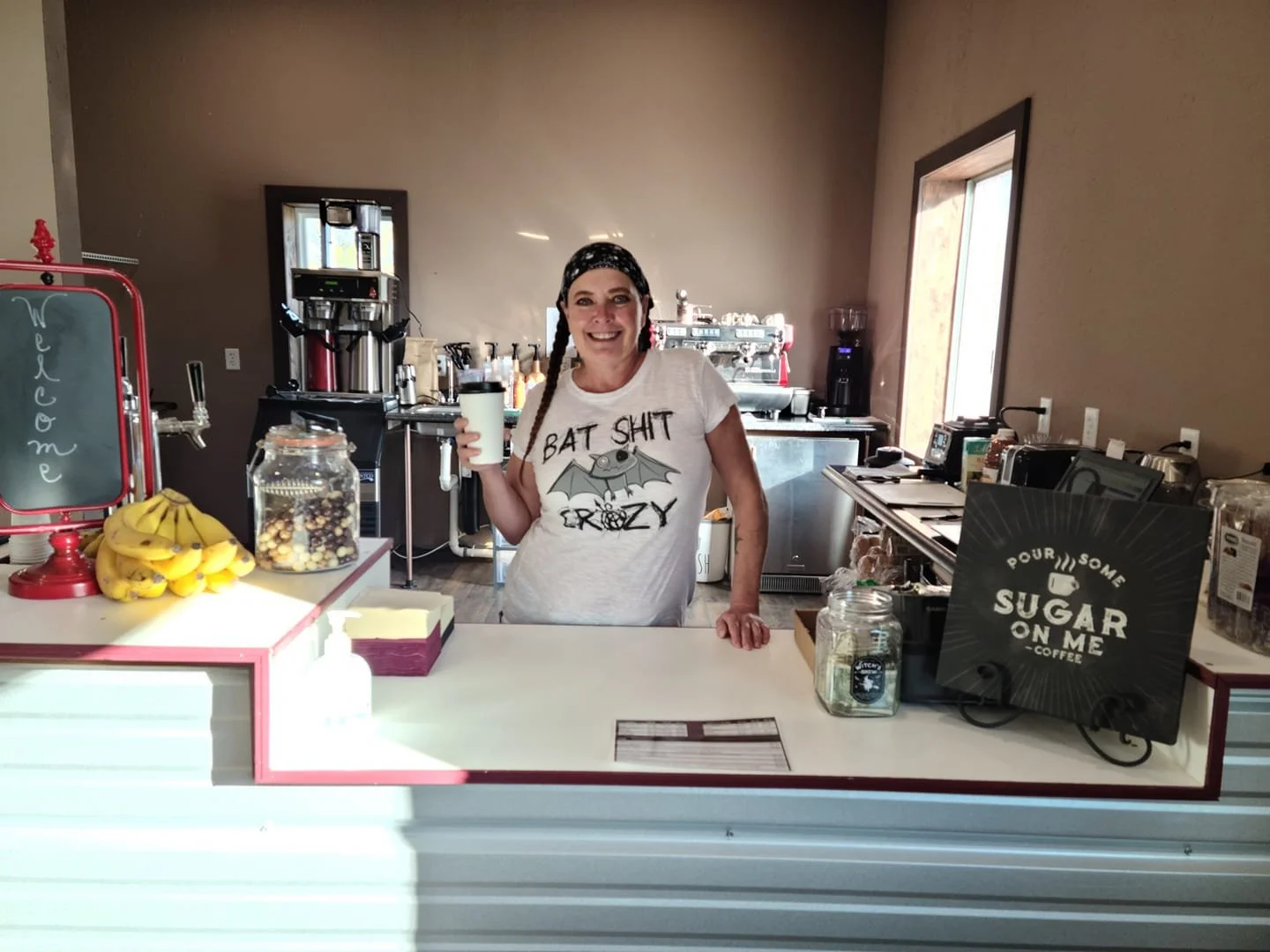 Nancy on opening day of Morning Wood Brew wearing a graphic t-shirt and celebrating the launch of the coffee house.