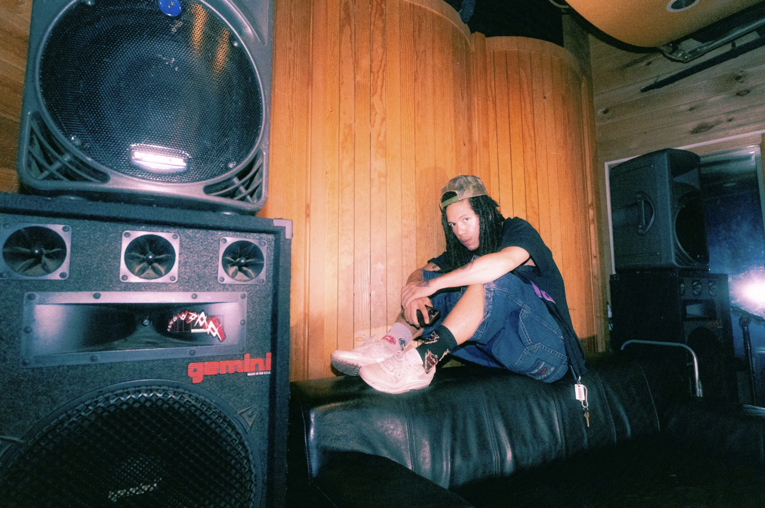 LIFEOFTHOM sitting on a couch in a music studio